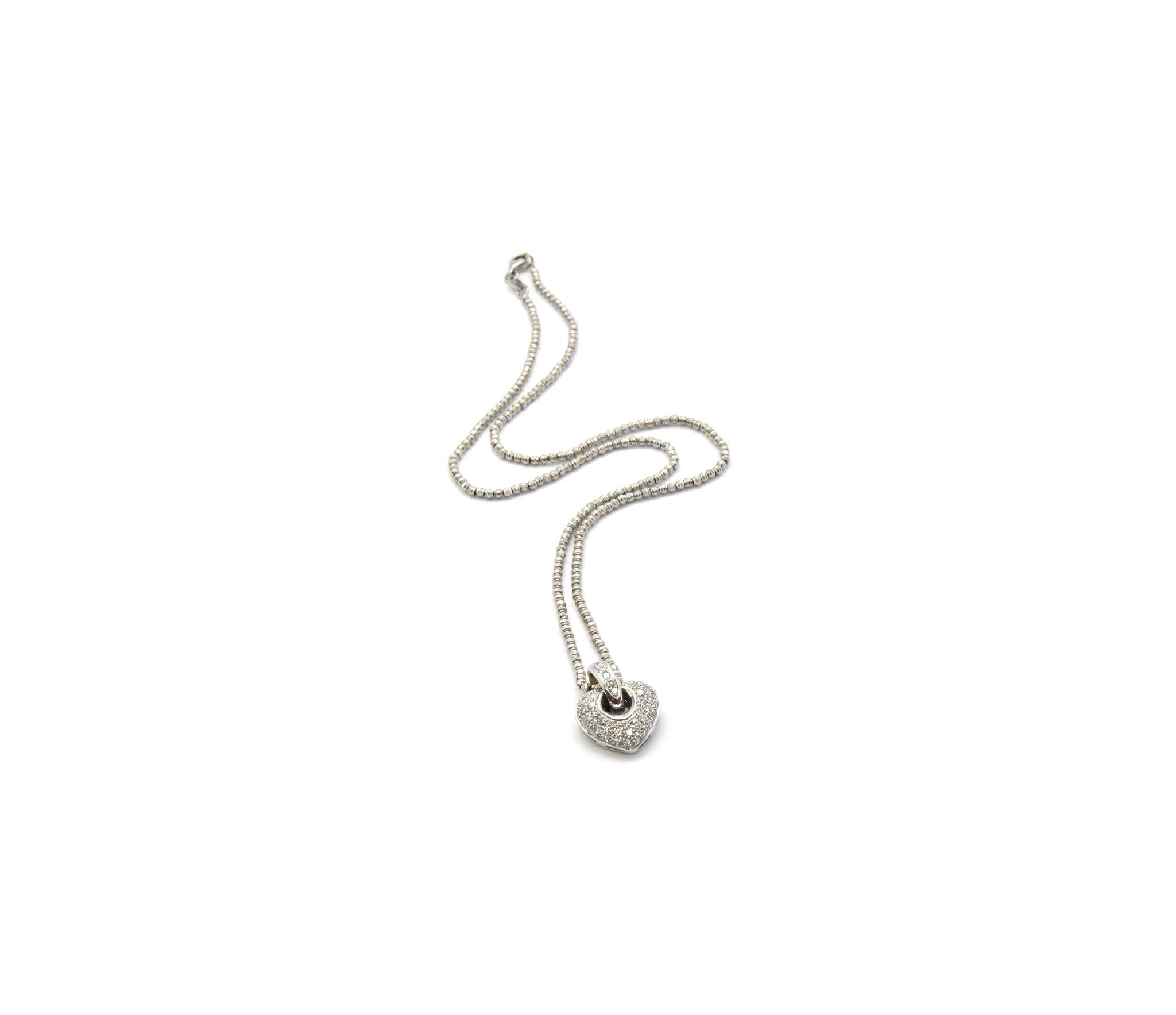 A 14k white gold heart pendant slides along a 14k white gold chain. The pendant is set with round brilliant diamonds. The stones have a total weight of 1.0 carat, and the stones are graded G in color and VS in clarity. The pendant measures 16x19mm,