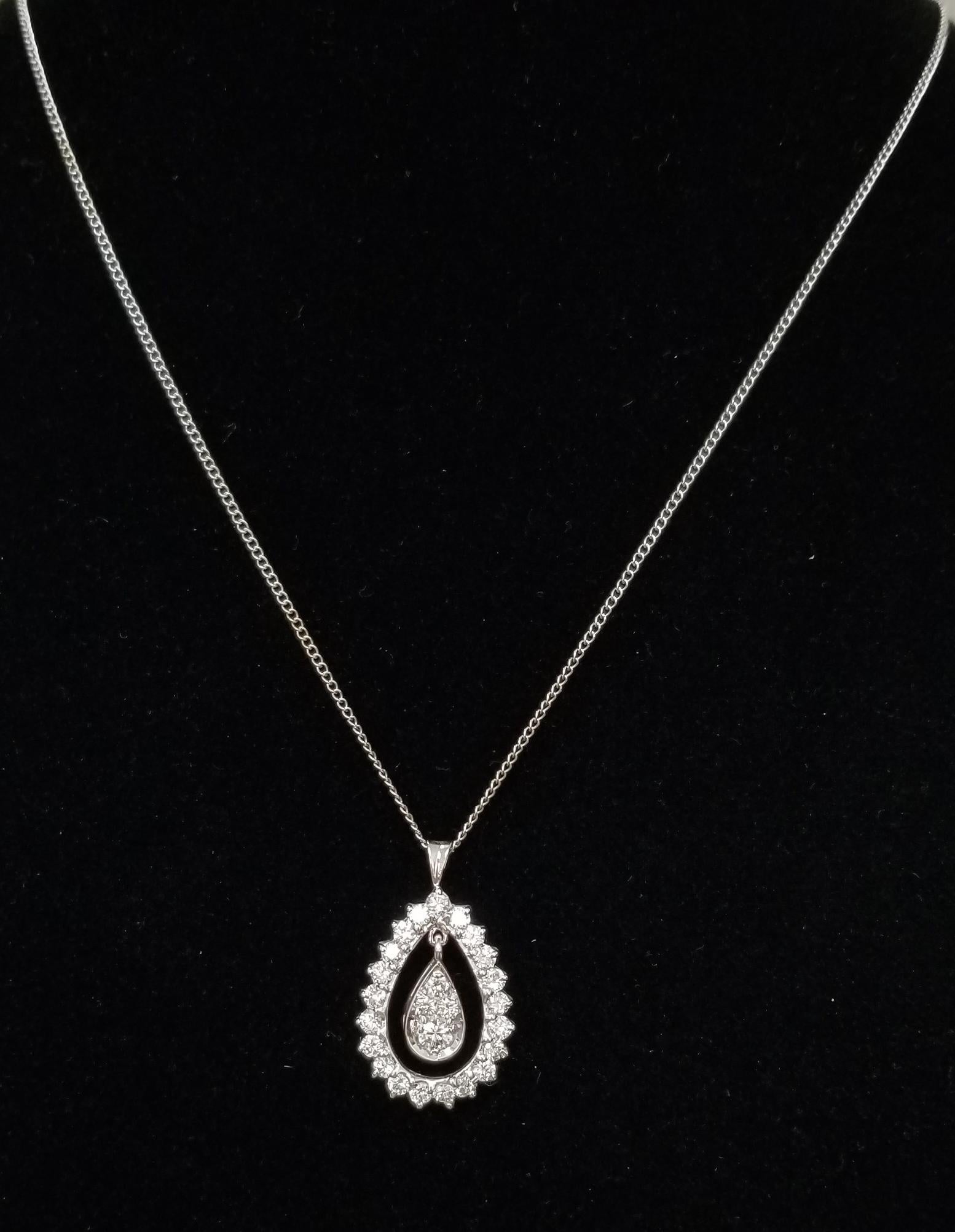 14k white gold pear shape diamond pendant, containing 25 round full cut diamonds of nice quality weighing 1.40cts. with a dangle diamond on the inside, on a 16 inch chain.