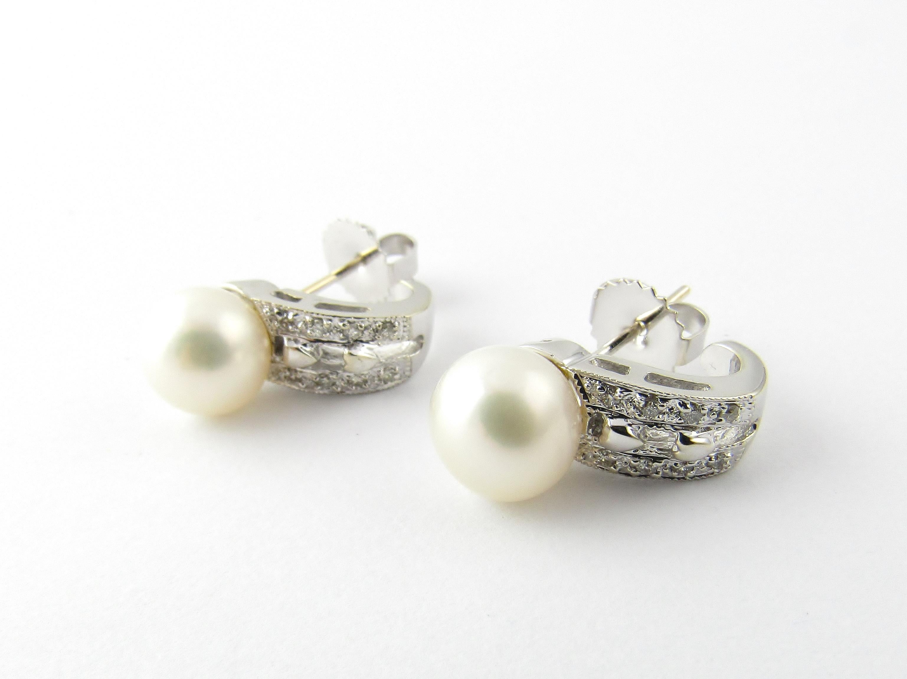 14 Karat White Gold Pearl and Diamond Earrings-

These elegant earrings each feature one white pearl (9 mm) accented with eight round brilliant cut diamonds and set in classic 14K white gold.  Push back closures.

Approximate total diamond weight: 