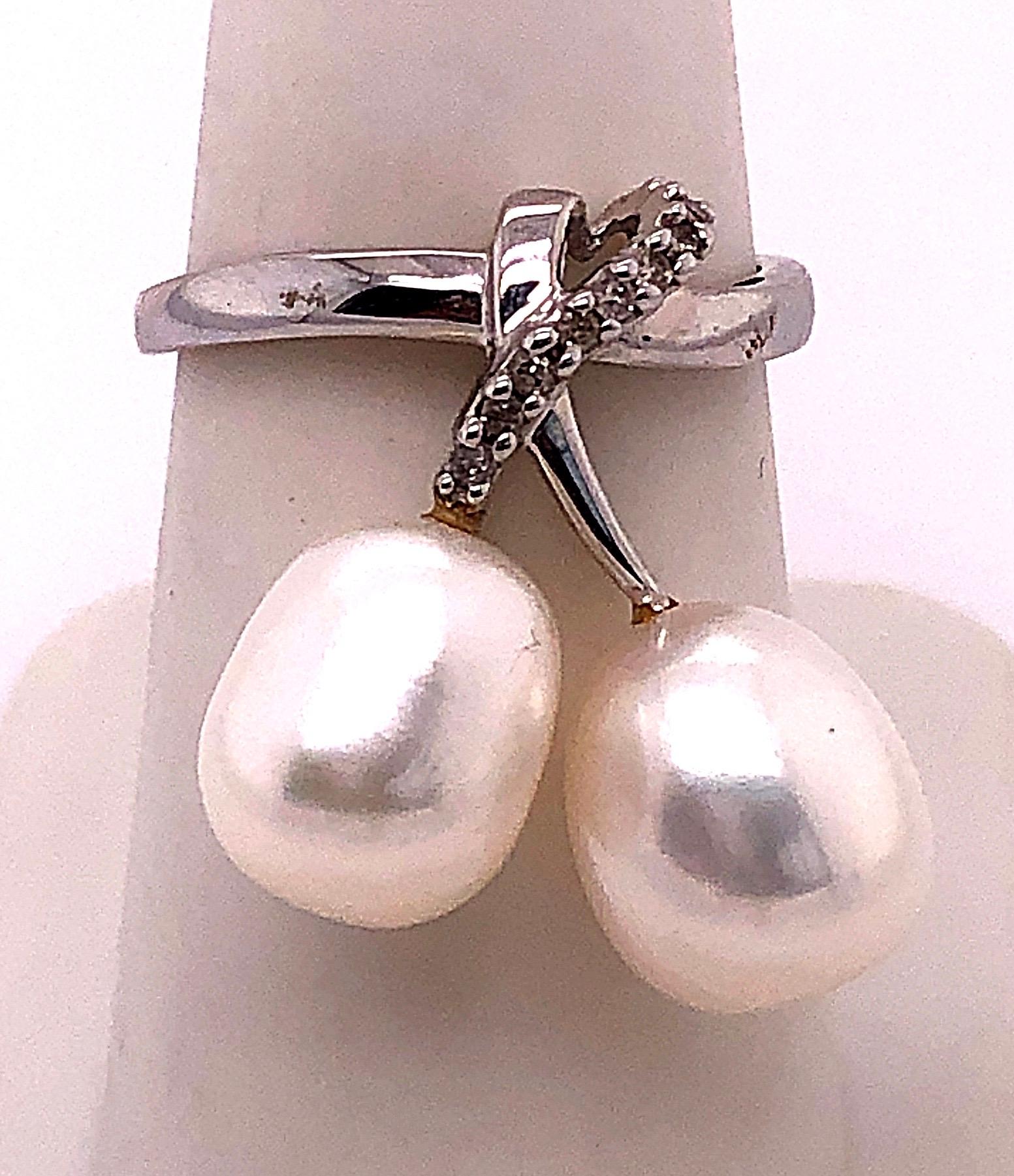14 Karat White Gold Pearl and Diamond Free Form Ring
0.06 total diamond weight.
2 piece 9.5 mm pearls
Size 7
2.04 grams total weight.
Height: 25 mm
Width: 22 mm