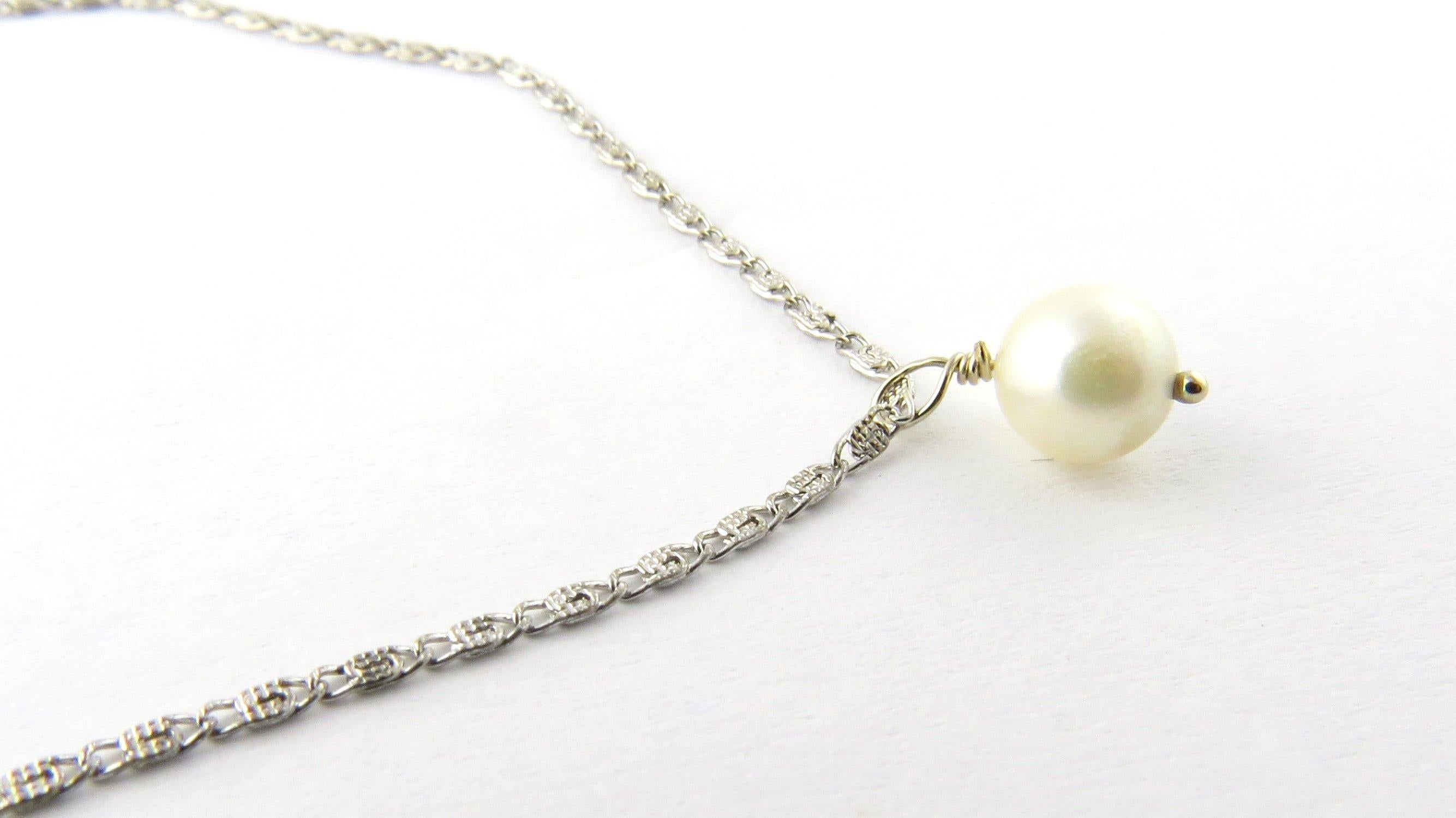 Vintage 14 Karat White Gold Pearl Drop Necklace- 
This elegant necklace features one round 6 mm pearl suspended from a classic 14K white gold necklace. 
Size: 18 inches 
Weight: 1.5 dwt. / 2.4 gr. 
Stamped 14KG 
Very good condition, professionally