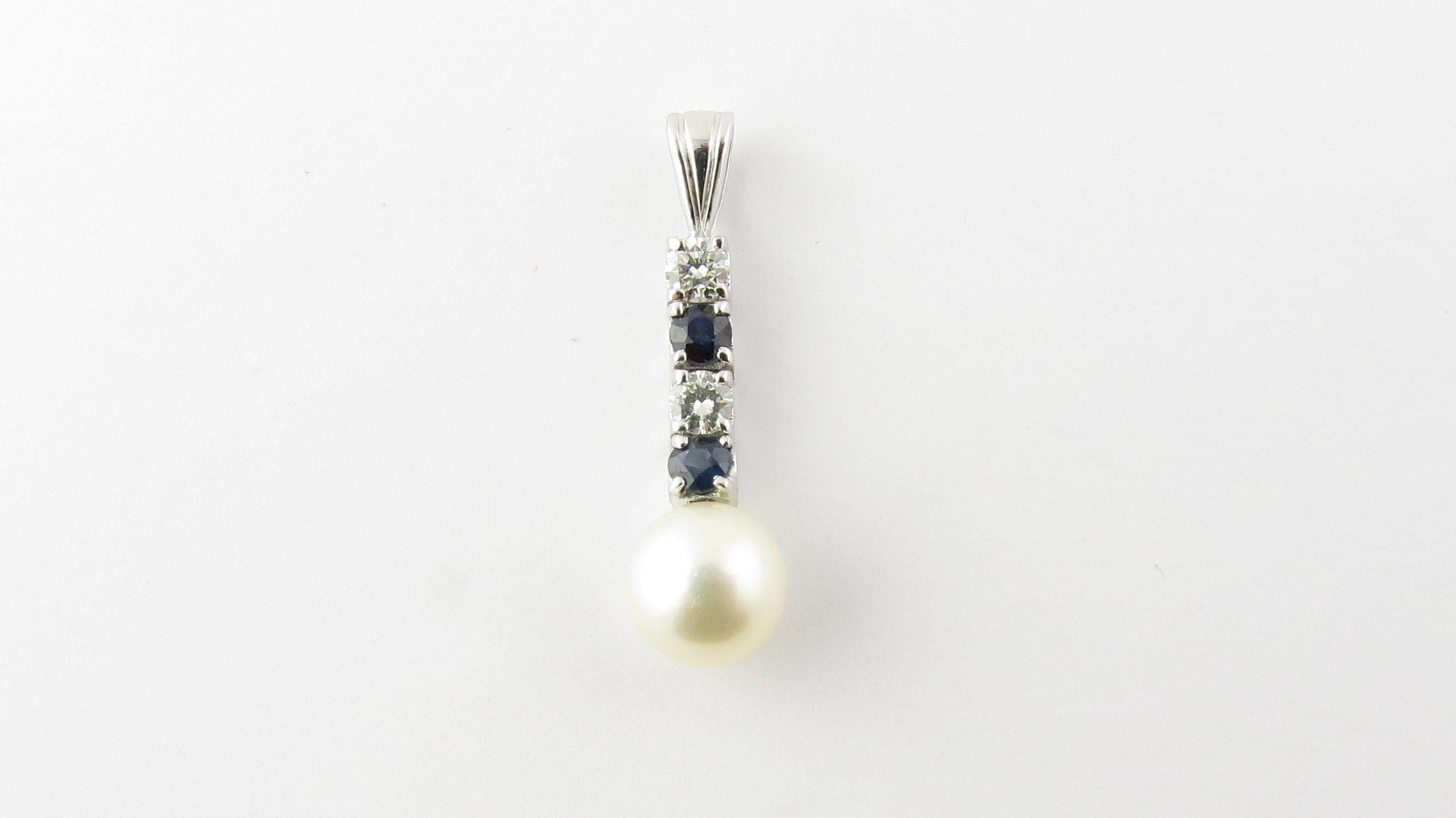 Vintage 14 Karat White Gold Pearl, Sapphire and Diamond Pendant- This lovely pendant features one cultured pearl (7.5 mm), two round genuine sapphires, and two round brilliant cut diamonds set in classic 14K white gold. Approximate total diamond