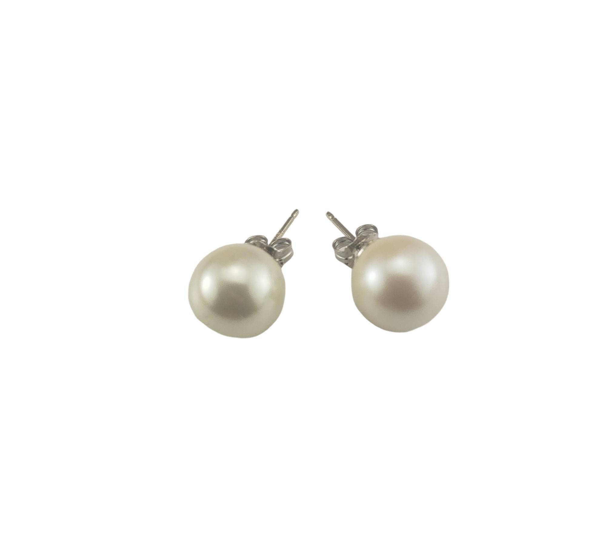Boucles d'oreilles en or blanc 14 carats avec perles-

Ces élégantes boucles d'oreilles présentent chacune une perle blanche (10 mm) sertie dans de l'or blanc classique 14K.  Fermetures à l'arrière.

Taille : 10 mm

Estampillé : 14KT

Poids : 1,5