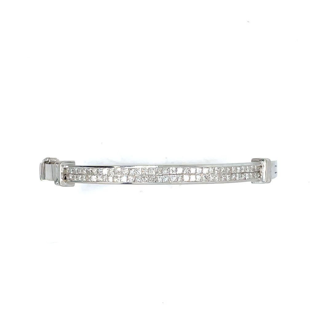 This bangle is a masterpiece of craftsmanship, with diamonds smoothly set for a continuous sparkle. The centerpiece features a double row of sleek princess cut diamonds in 14 karat white gold. The bangle's delicate and well-made design holds 3.50