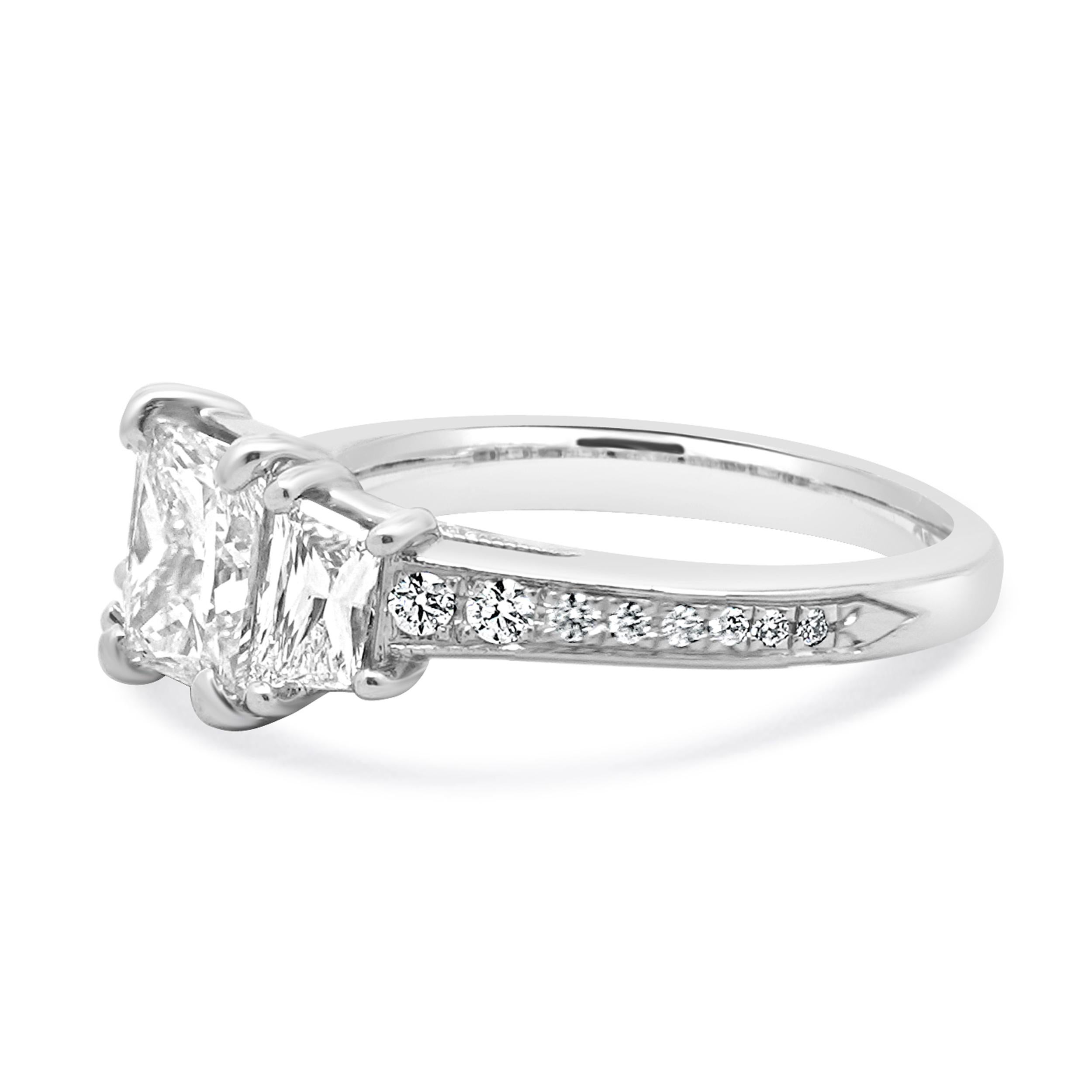 Material: oro blanco de 14 quilates
Diamante central: 1 talla radiante = 1,12ct
Color: H
Claridad: SI2
Diamante: 2 talla trapezoidal = 0,88ctw
Color: H / I
Claridad: SI1
Diamante: 28 talla redonda = 0,30ctw
Color: I
Claridad: SI1
Tamaño del anillo: