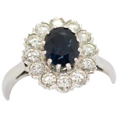 14 Karat White Gold Ring set with a large Sapphire and 12 white Diamonds.