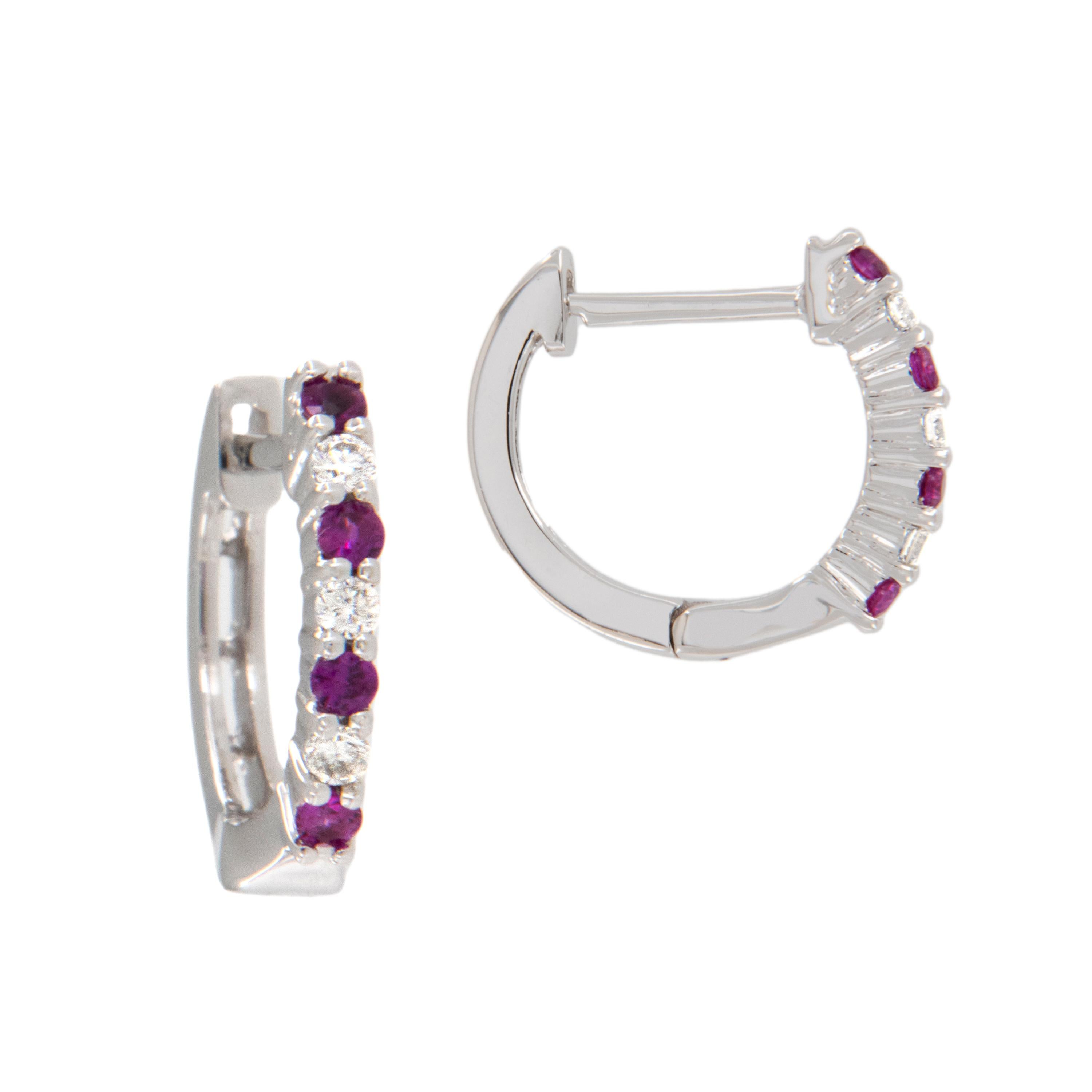 These bright mini hoop earrings are made in 14 karat white gold and look sweet on your ears! Shared prong set with 8 juicy red  rubies = 0.10 Cttw & 6 fine white diamonds = 0.06 Cttw these will be the most comfortable earrings you own because the