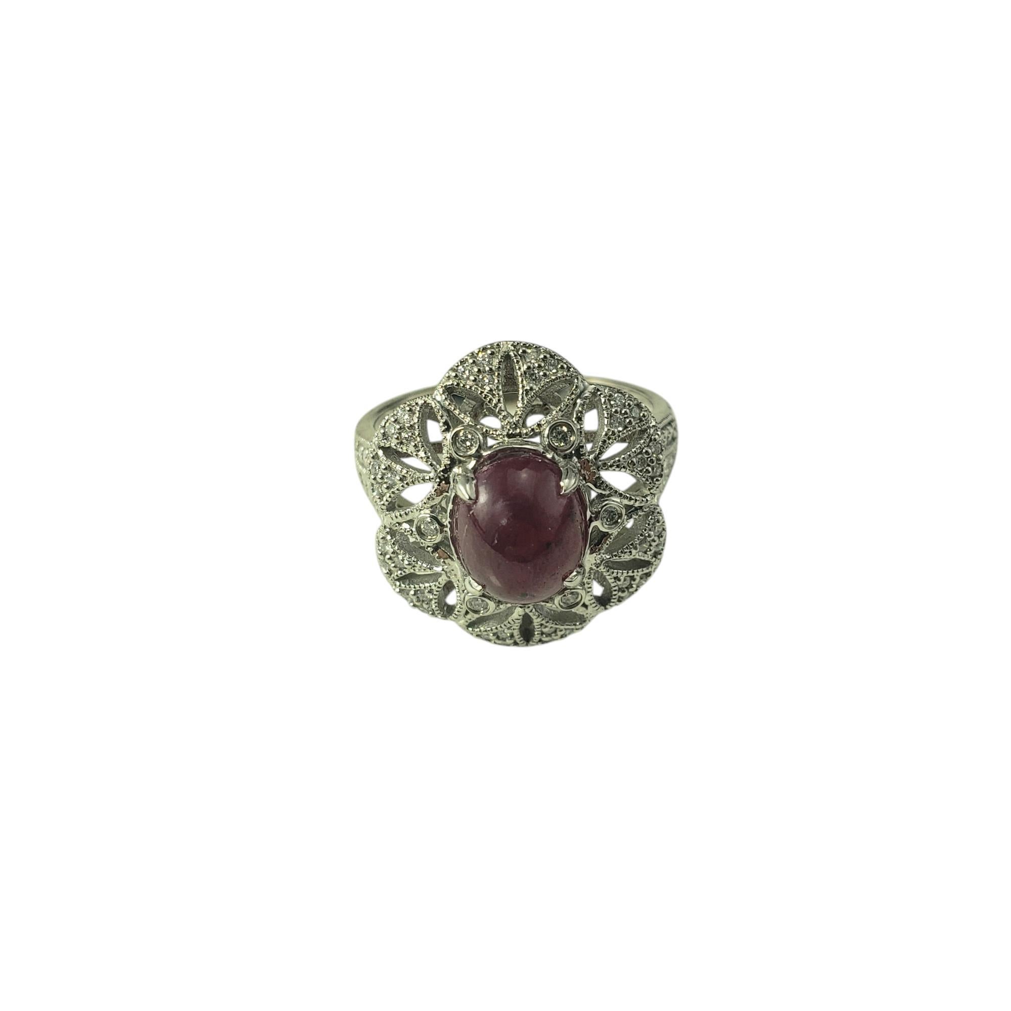 14 Karat White Gold Ruby and Diamond Flower Ring Size 6.5 JAGi Certified-

This stunning ring features one oval cabochon cut ruby (8.3 mm x 6.9 mm) and 62 round brilliant cut diamonds set in beautifully detailed 14K white gold filigree. Width: 18