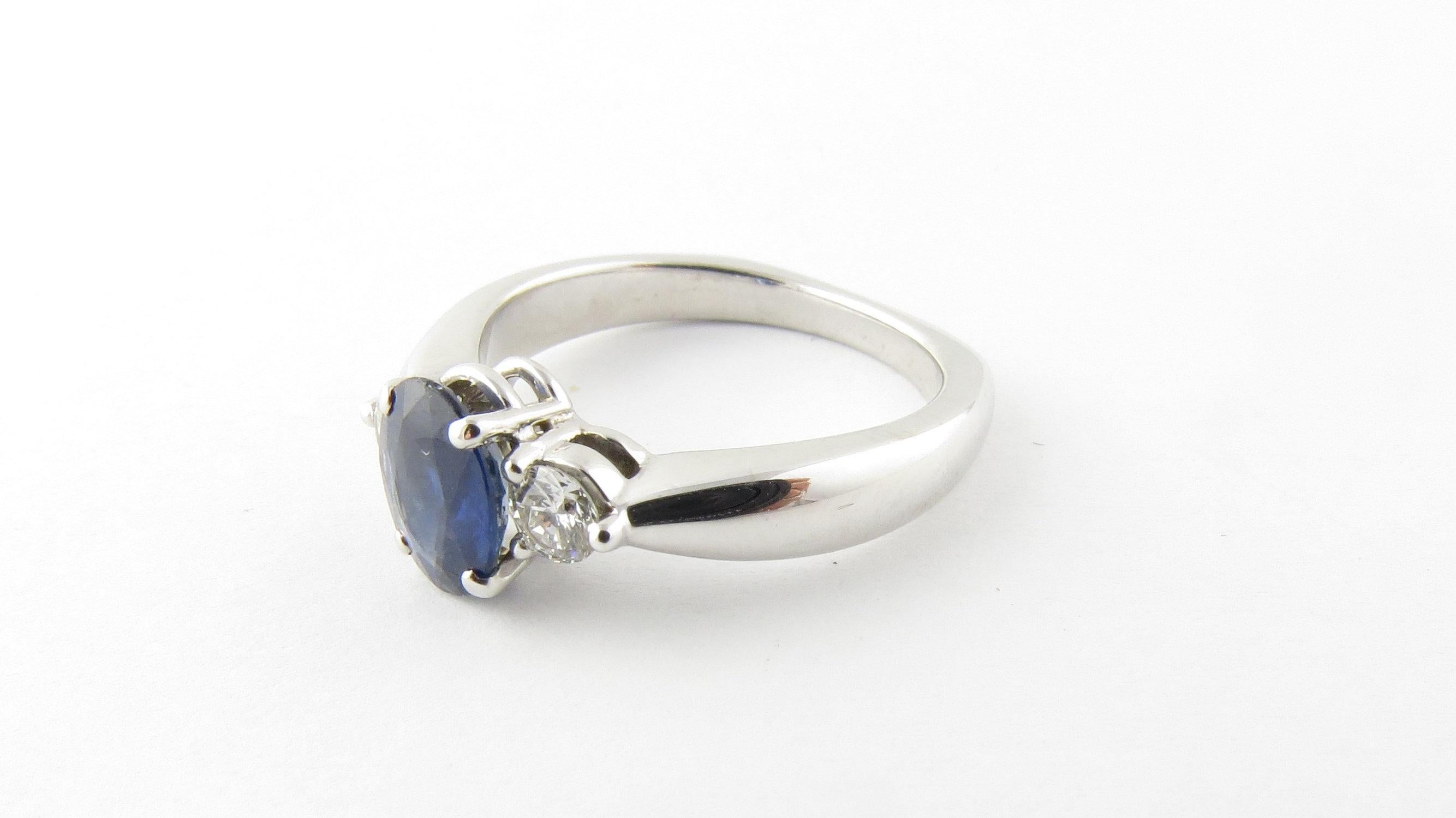 Vintage 14 Karat White Gold Sapphire and Diamond Ring Size 7.5- 
This elegant ring features one oval sapphire (8 mm x 6 mm) and two round brilliant cut diamonds (.15 ct. each) set in classic 14K white gold. Shank measures 2 mm. 
Approximate total