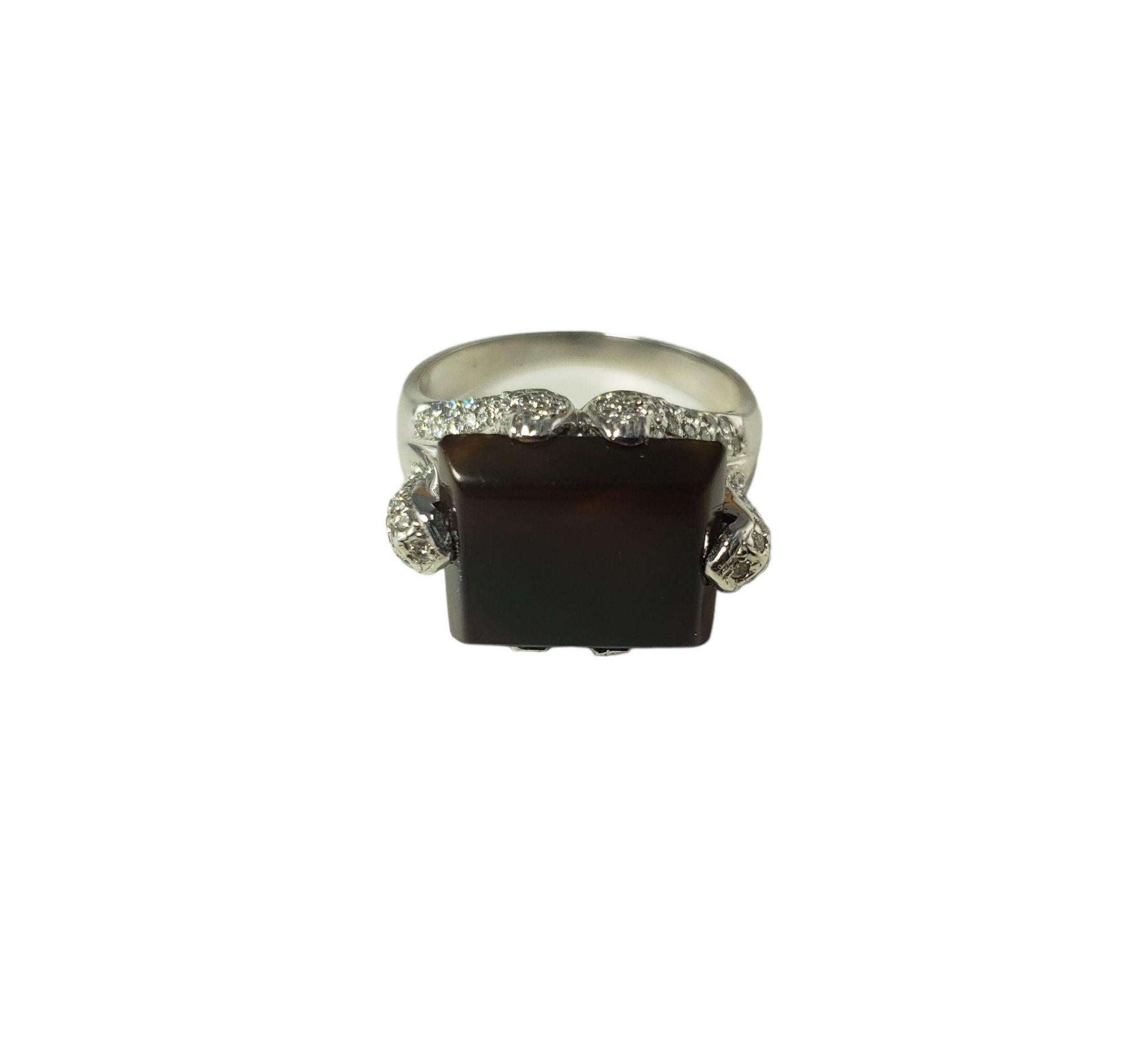 This elegant ring features one tablet cut sard chalcedony stone (14 mm x 11 mm) and 105 round brilliant cut diamonds set in beautifully detailed 14K white gold.  Shank:  2.3 mm.  Width:  14 mm.

Chalcedony weight:  4.20 ct.

Total diamond weight: 