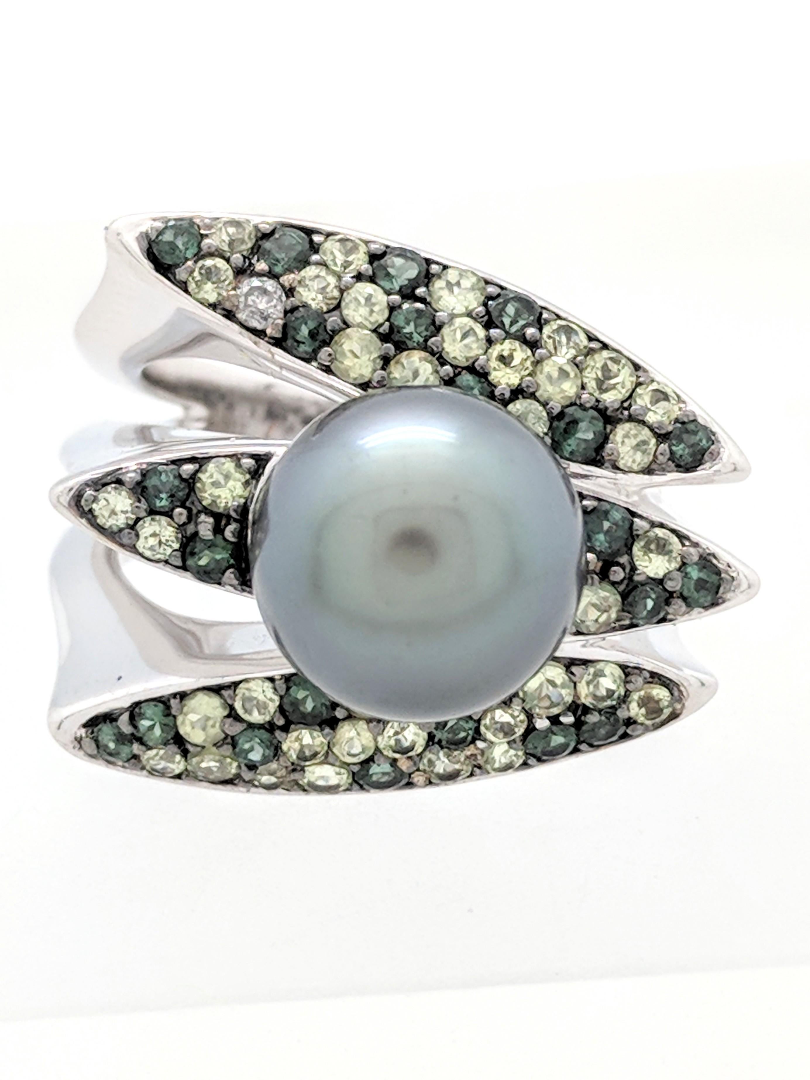 You are viewing a unique Tahitian pearl, peridot & tourmaline ring. This ring is crafted from 14k white gold and weighs 14.3 grams. It features approximately (1) 10mm Tahitian pearl and a variety of different shades of green gemstone, ie peridot,