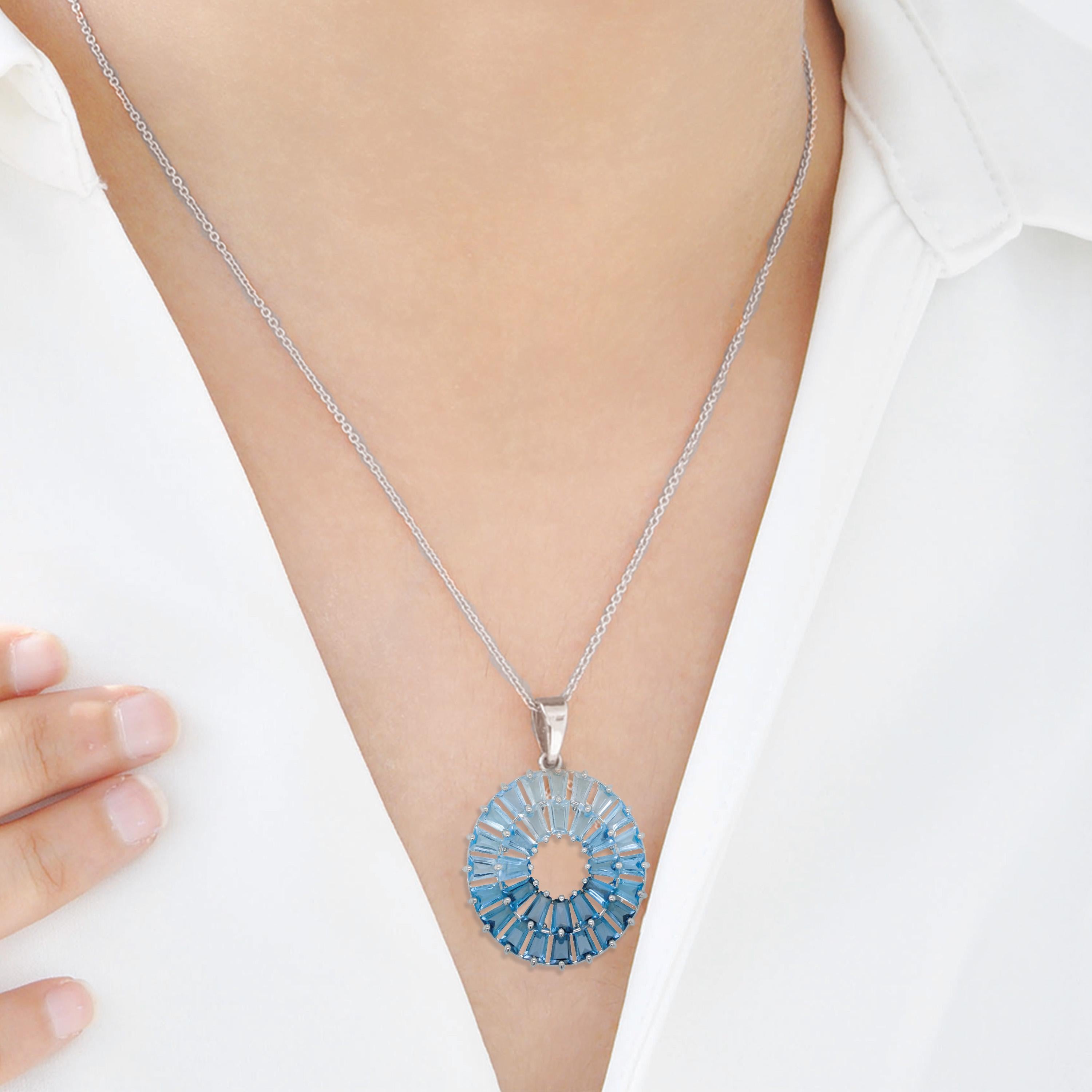 This exquisite pendant is handcrafted in 14-karat white gold and showcases a vibrant array of blue topaz gemstones, making it a true celebration of brilliance and elegance. The design features 32 carefully selected tapered baguette-cut blue topaz