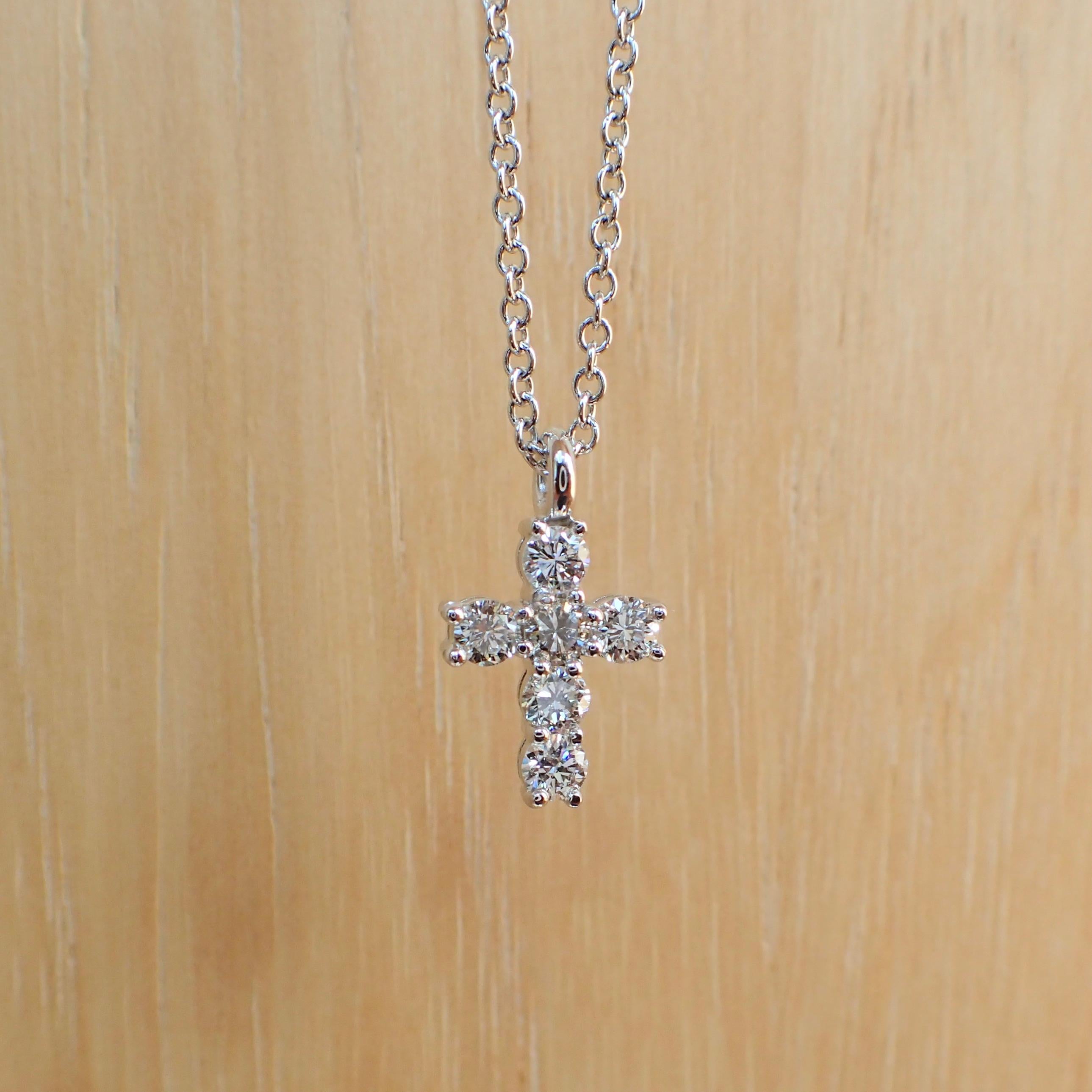 14k white gold tiny cross with six (6) Round Brilliant Cut diamonds weighing a total of 0.30 carats with Color Grade G-H and Clarity Grade SI. The cross hangs from a 16