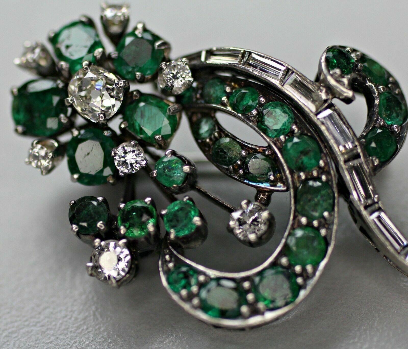 This is a 14k white gold vintage art deco style emerald and diamond brooch. The natural emeralds, approximately 2 carat total weight, are even dark green in color. There are approximately 1 carat total weight of white brilliant diamonds adjacent to