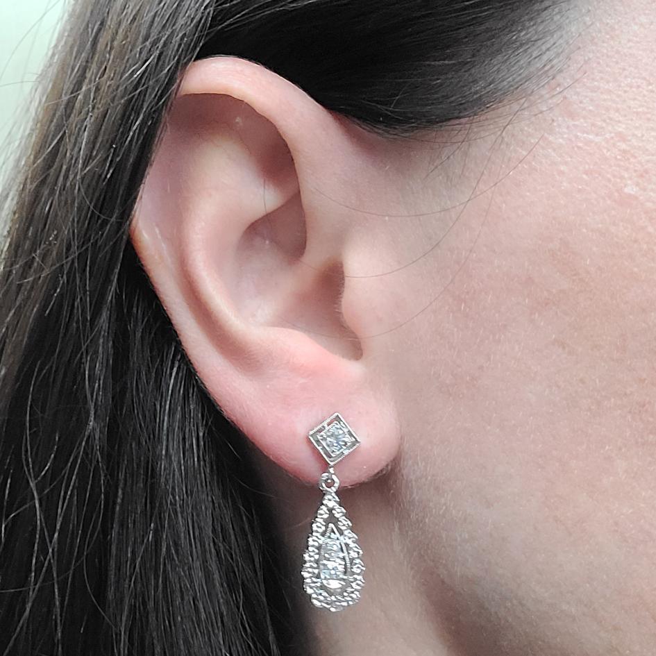 14 Karat White Gold Pear Drop Earrings Featuring 6 Round Diamonds Of SI Clarity & H Color Totaling 0.33 Carat. Finished Weight is 4.0 Grams. Pierced Post With Friction Backs. Length Is 1.125 Inches.
