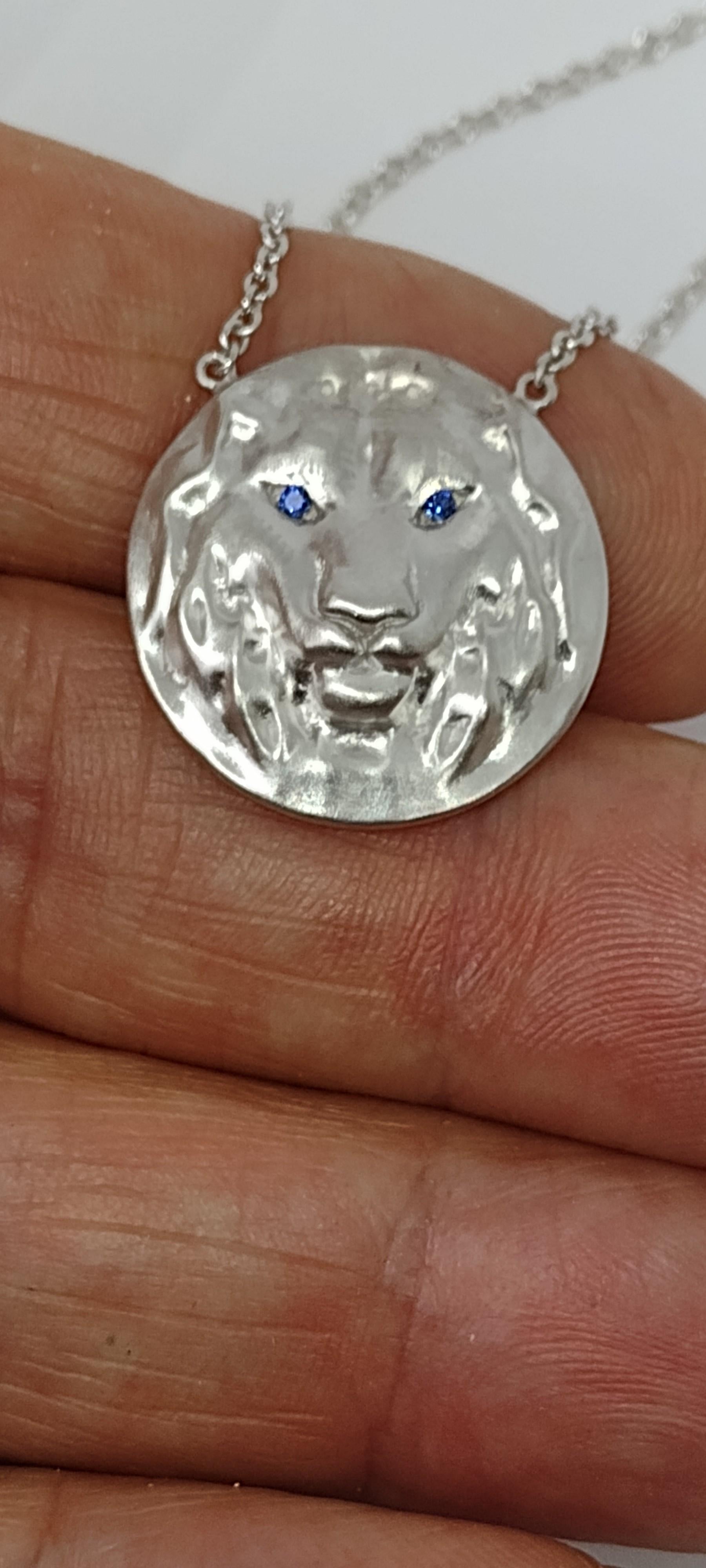 Tiffany designer , Thomas Kurilla created this 14k White Gold Lion Pendant,  Matte finish, 21 mm diameter x 5.4 high on a 18 inch chain 1.5 mm wide. 1.4 mm sapphire eyes . This chain is for women. It is too fine for men.

 I would recommend a 1.7