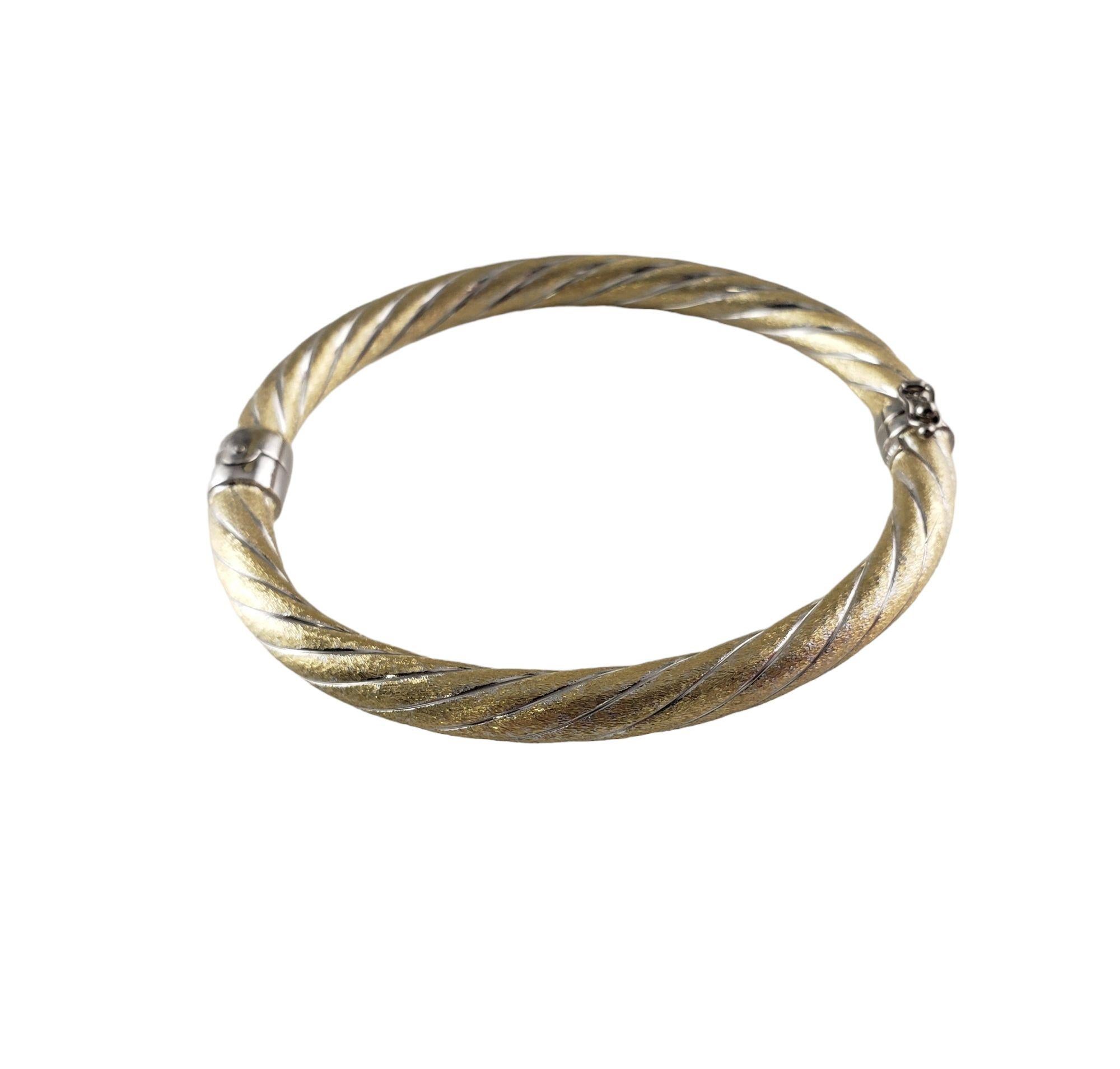 Vintage 14 Karat Yellow Gold and White Bangle Bracelet-

This elegant hinged bangle bracelet is crafted in meticulously detailed 14K yellow and white gold. Width: 6 mm.

Size: 7 inches

Weight: 10.8 gr./ 6.9 dwt.

Stamped: 14K

Very good condition,