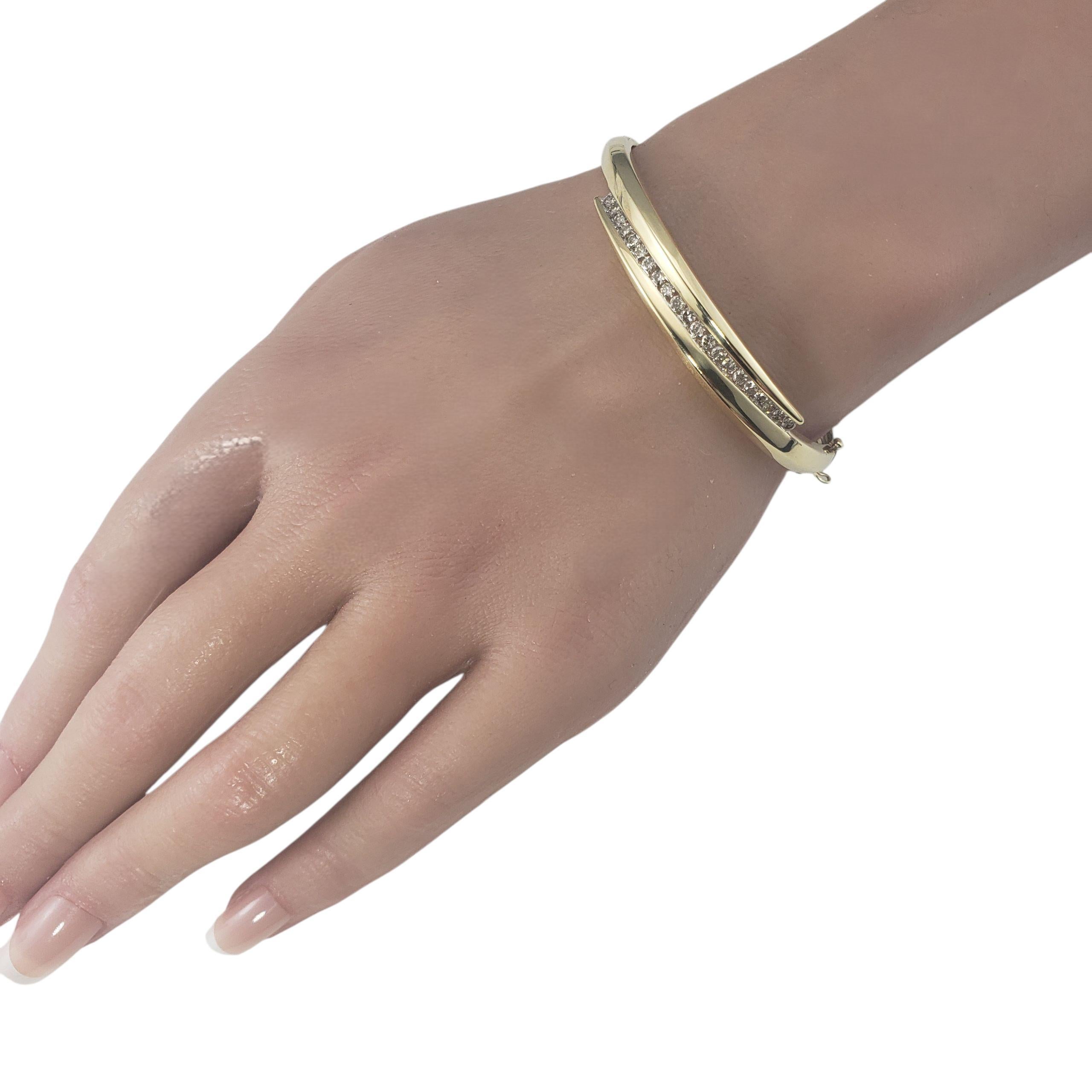 14 Karat Yellow and White Gold and Diamond Bangle Bracelet-

Timeless sophistication meets modern simplicity in this beautifully crafted 14K yellow gold bangle accented with 21 sparkling round brilliant cut diamonds set in 14K white gold. Secured