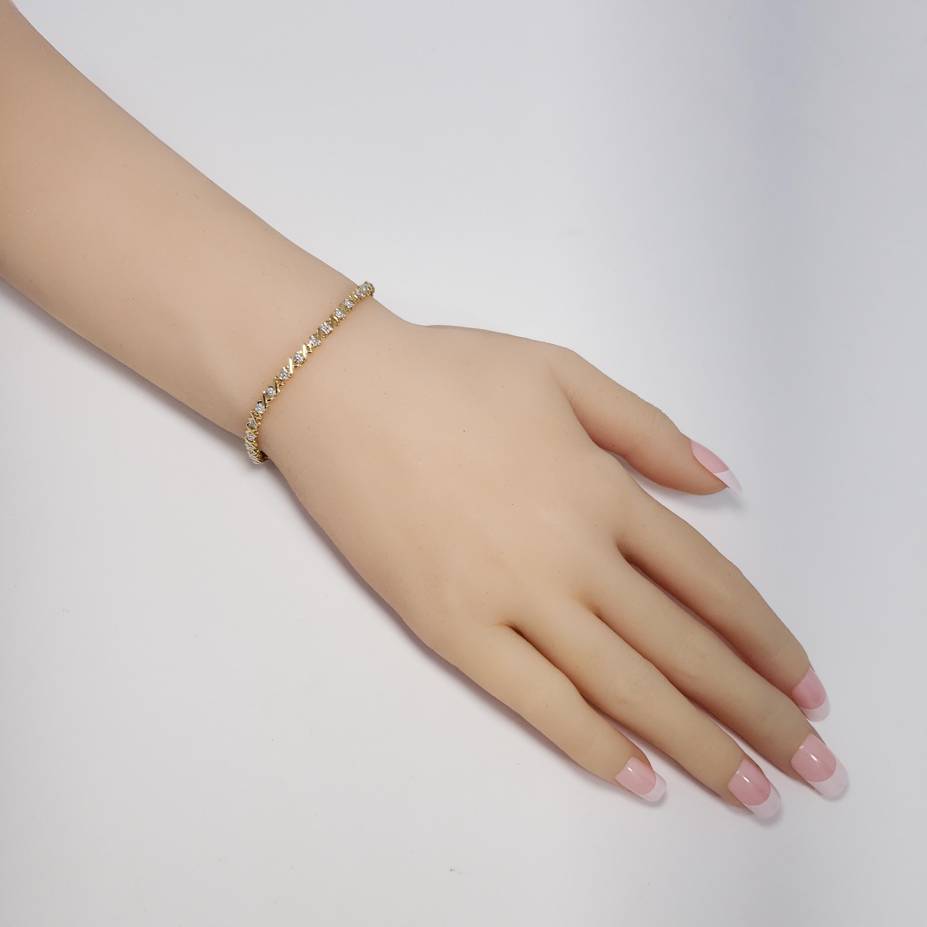 A bracelet featuring white and yellow 14K gold links, accented with open back diamonds.

The toggle clasp does not click when inserted, but the snap fastener allows for secure closure.

Length: 17.5cm