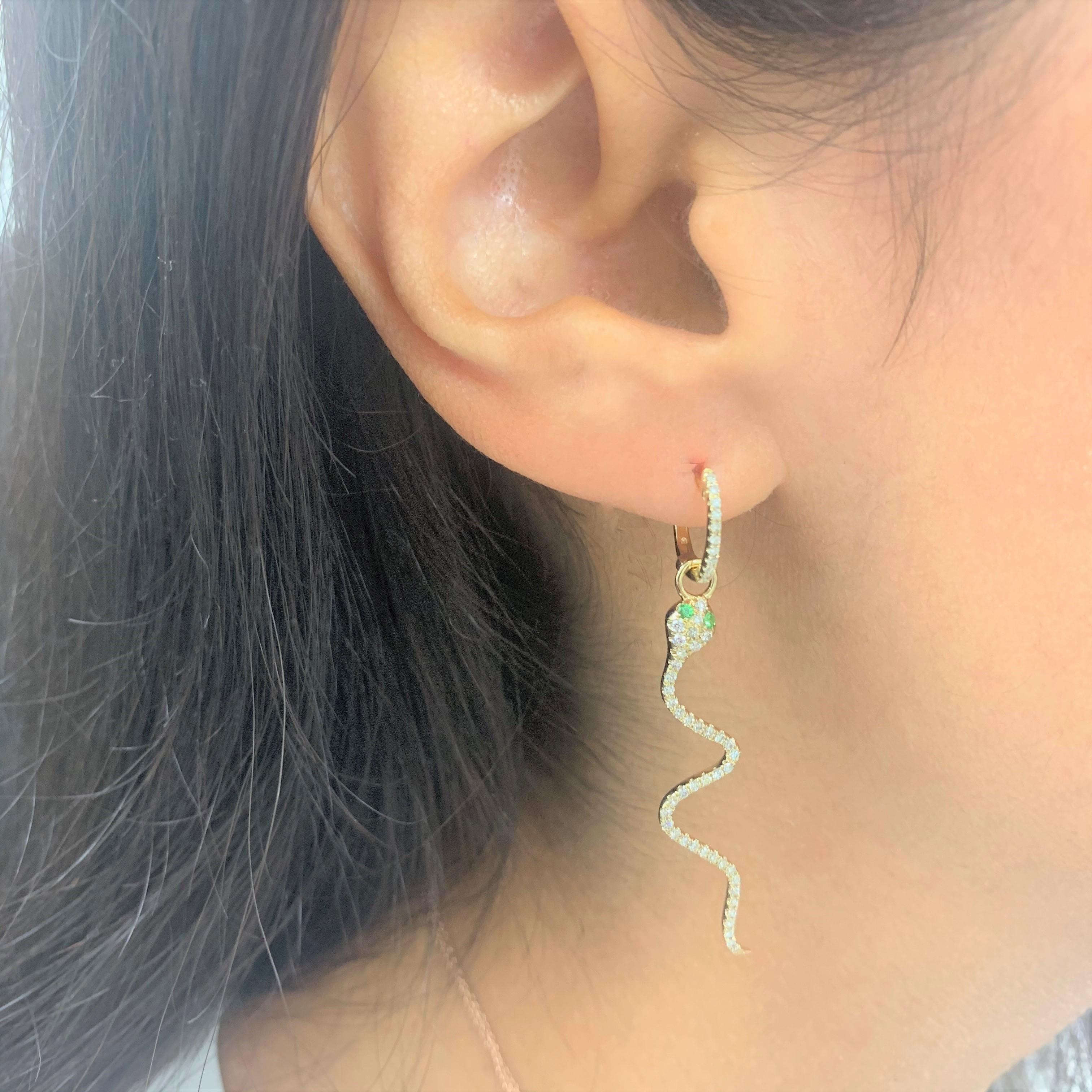 Cette paire de boucles d'oreilles pendantes en or jaune 14 carats est composée de diamants blancs ronds de 0,53 carats et de tsavorites de 0,08 carats. Fermeture de sécurité à levier. Ces boucles d'oreilles ont une longueur de chute de 2