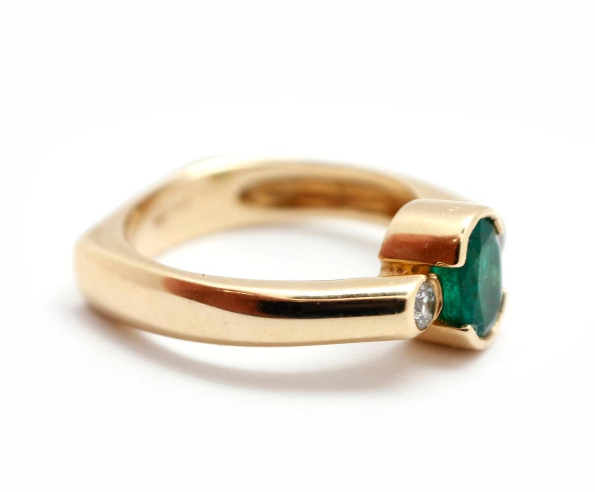 This ring is made in 14k yellow gold. It holds an oval-cut emerald weighing about 0.75ct. There are two round accent diamonds for an additional weight of 0.17cttw. The ring measures 8mm wide, and it weighs 5.5 grams. The ring is size 6.75.