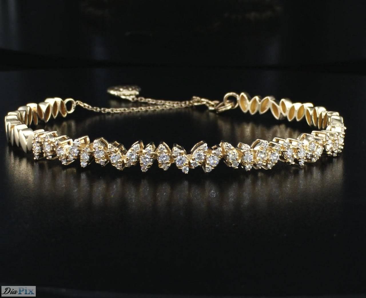 One of a kind 14K yellow gold diamond fashion bangle bracelet. This leaf motif bracelet is done with precise craftsmanship and fits an everyday look as well as a classic evening look. Each leaf is set with 3 round diamonds next to each other which