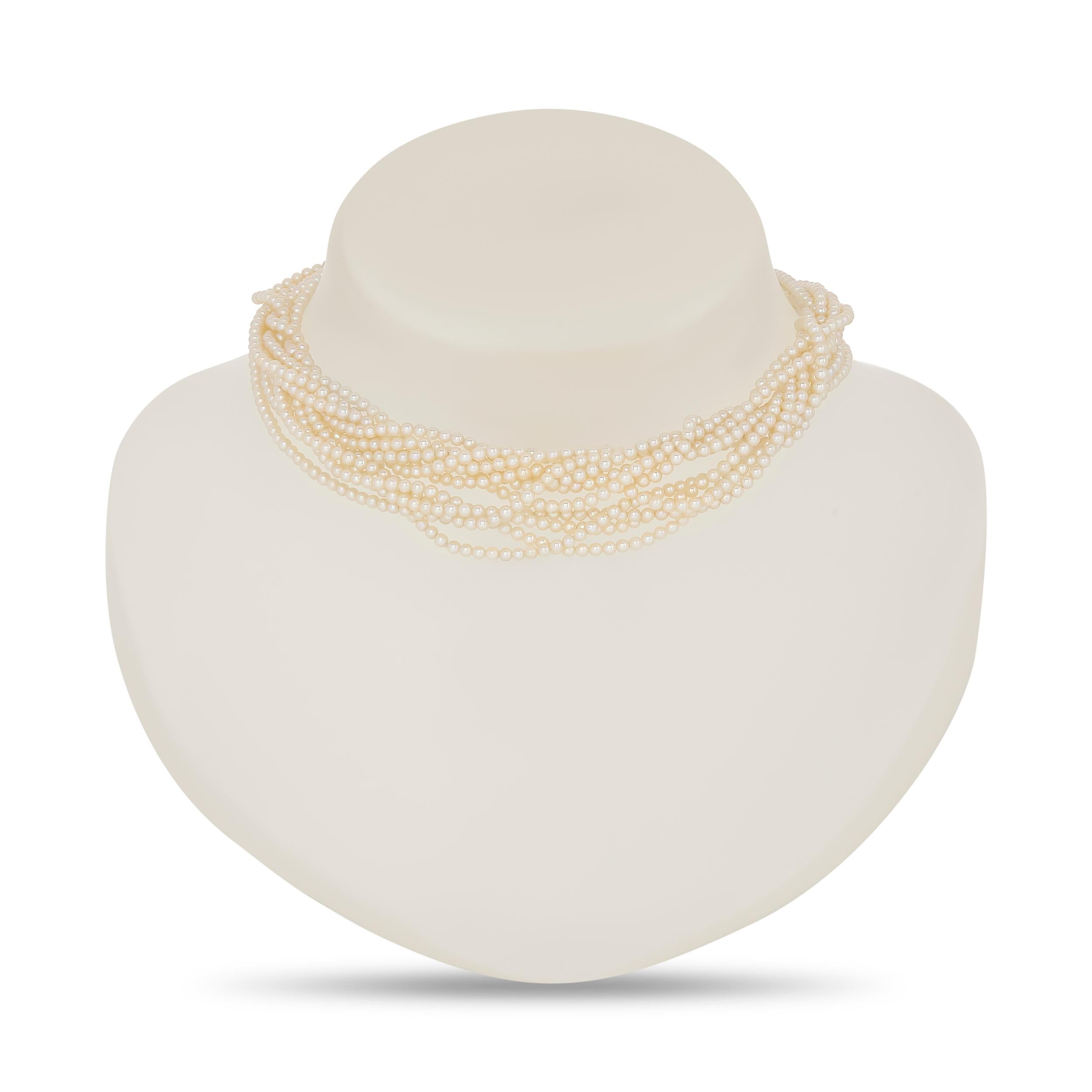 This opulent necklace features multiple strands of delicate cream-colored pearls, gathering at a decorative 14 karat yellow gold clasp intricately adorned with a floral or bow-like design of smaller pearls.

16