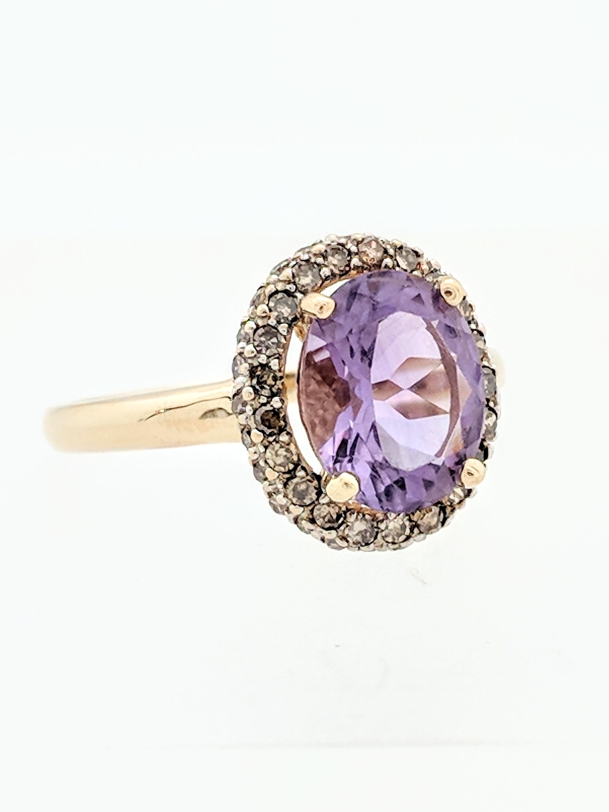 You are viewing a beautiful Amethyst and Champagne Diamond Halo Ring. Any woman would love to add this piece to their collection! This ring is crafted from 14k yellow gold and weighs 3.4 grams. It features one (1) 10x8mm (2.40ct) natural oval shaped