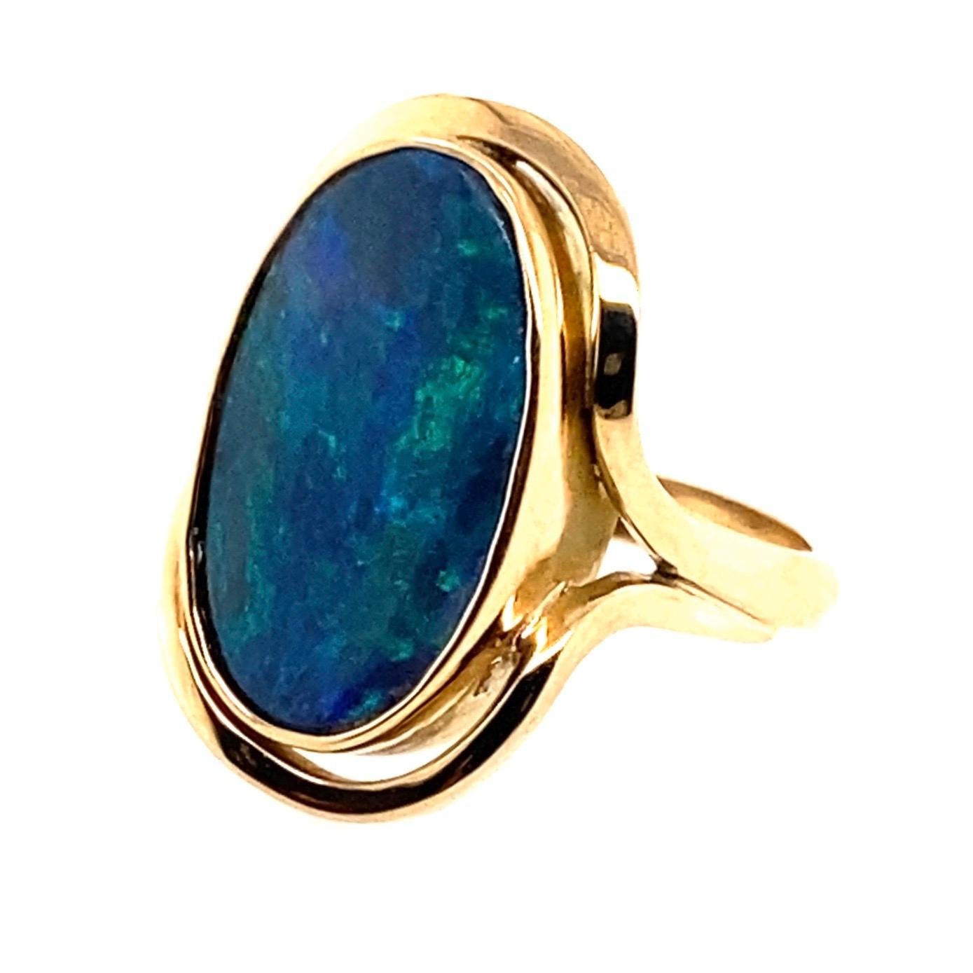 14 Karat Yellow Gold 3.60 Carat Australian Black Opal Cocktail Ring

Handmade 14kt yellow gold ring contains a solid oval cabochon Australian black opal set in a bezel setting. Two curved wires wrap around the center stone. Band stamped 14ct,