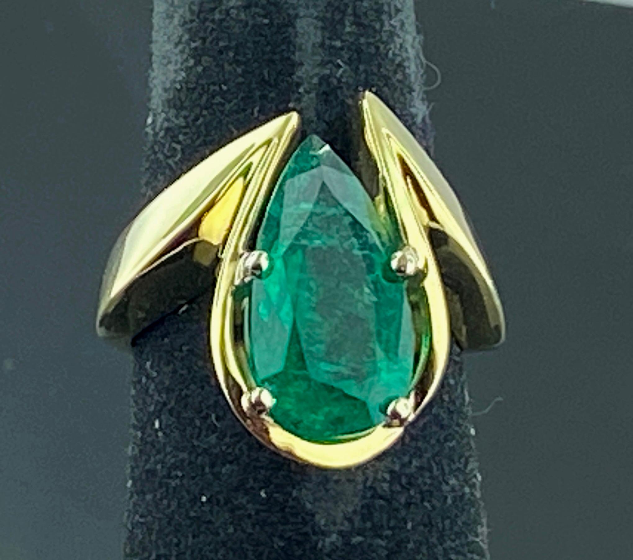 A very unique setting in 14 karat yellow gold with a 4.20 carat Pear Shaped Emerald as its focus.  Ring size is 7.25.