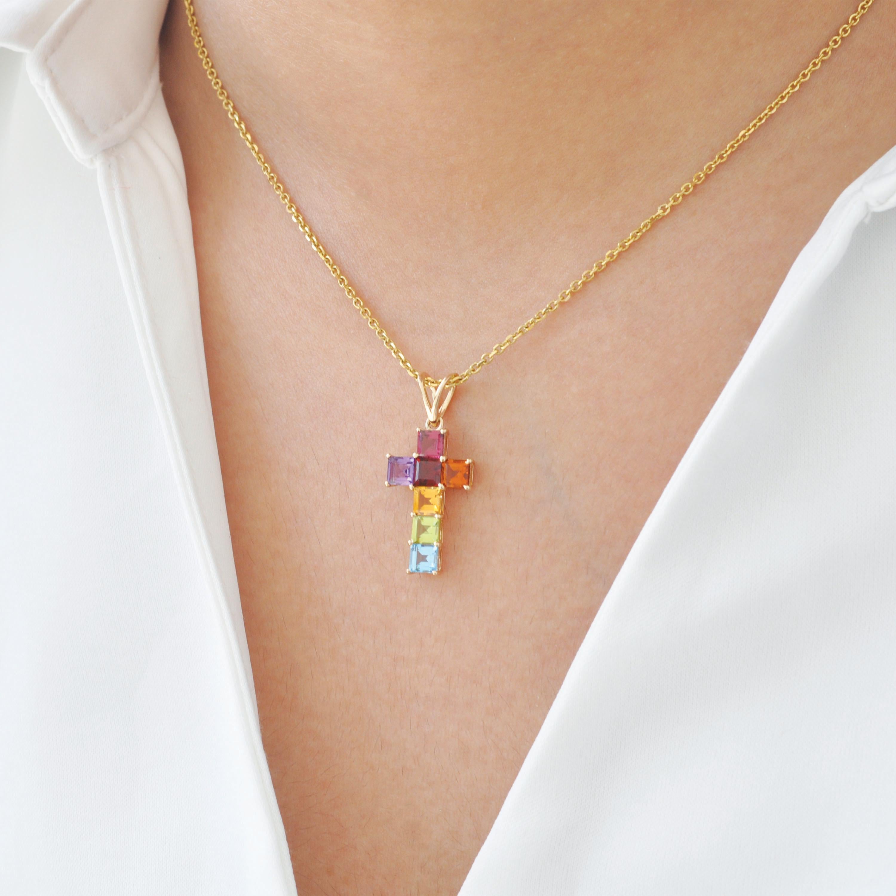 Elegant et symbolique, ce pendentif croix en pierres précieuses arc-en-ciel en or jaune 14 carats est une vibrante expression de foi et de style. Conçu avec précision, le pendentif est orné de pierres précieuses de 4 mm de côté, chacune