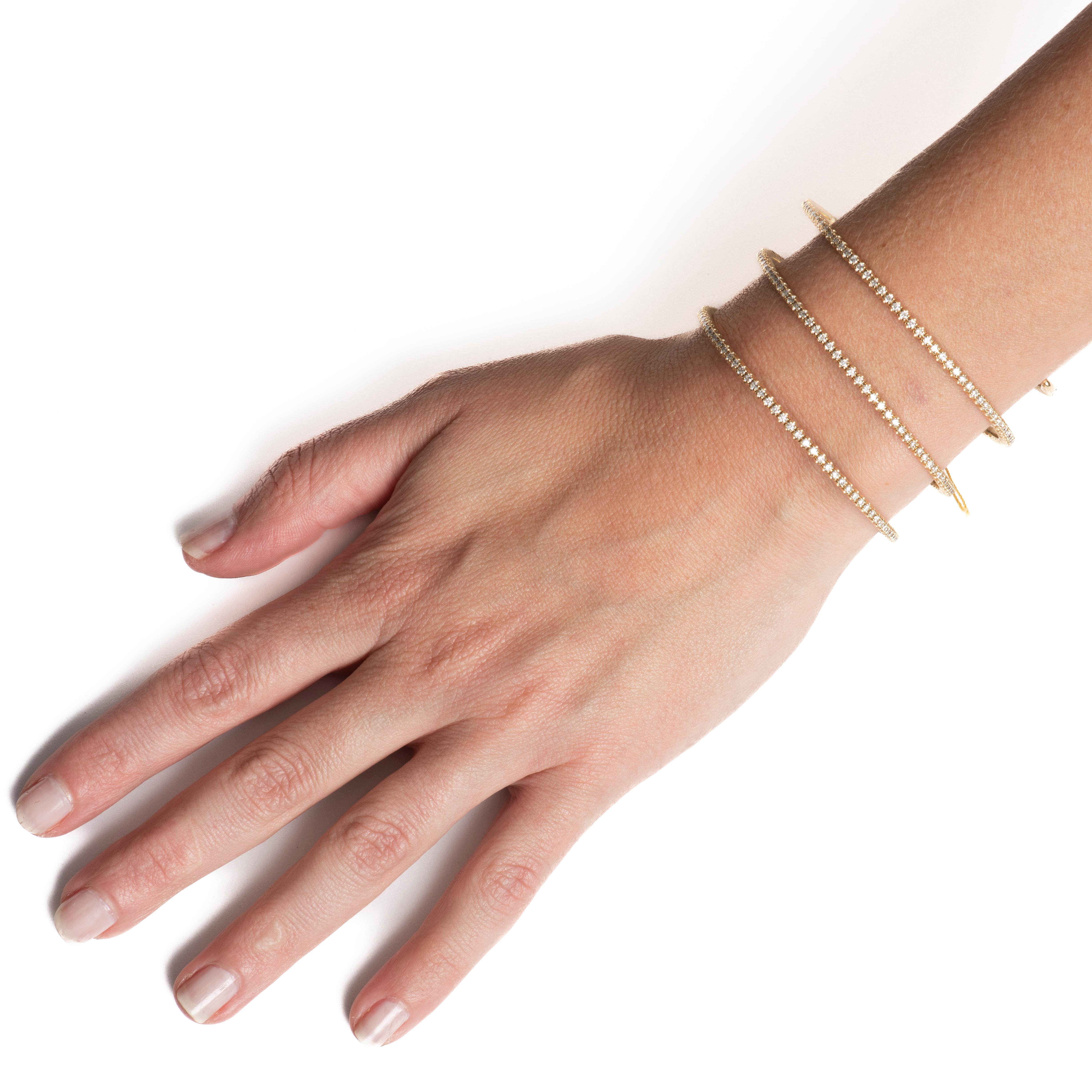 Ce bracelet flexible présente un poids total de 5,42 carats de diamants naturels ronds de taille brillant, sertis sur trois rangs qui s'enroulent autour de votre bras. Il est serti dans de l'or jaune 14 carats. Il est délicat à porter tous les jours