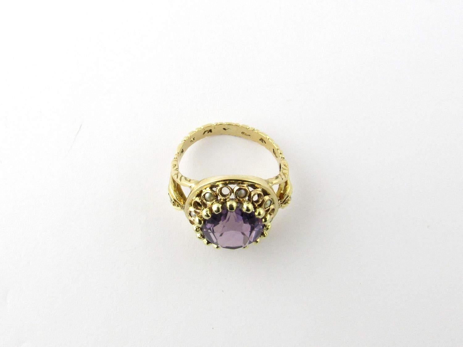 Vintage 14 Karat Yellow Gold Amethyst and Pearl Ring Size 5.75- 

This beautiful ring features a genuine amethyst (13 mm x 10 mm) surrounded by seed pearls and set in beautifully detailed yellow gold. Accented with a clear stone on each side of