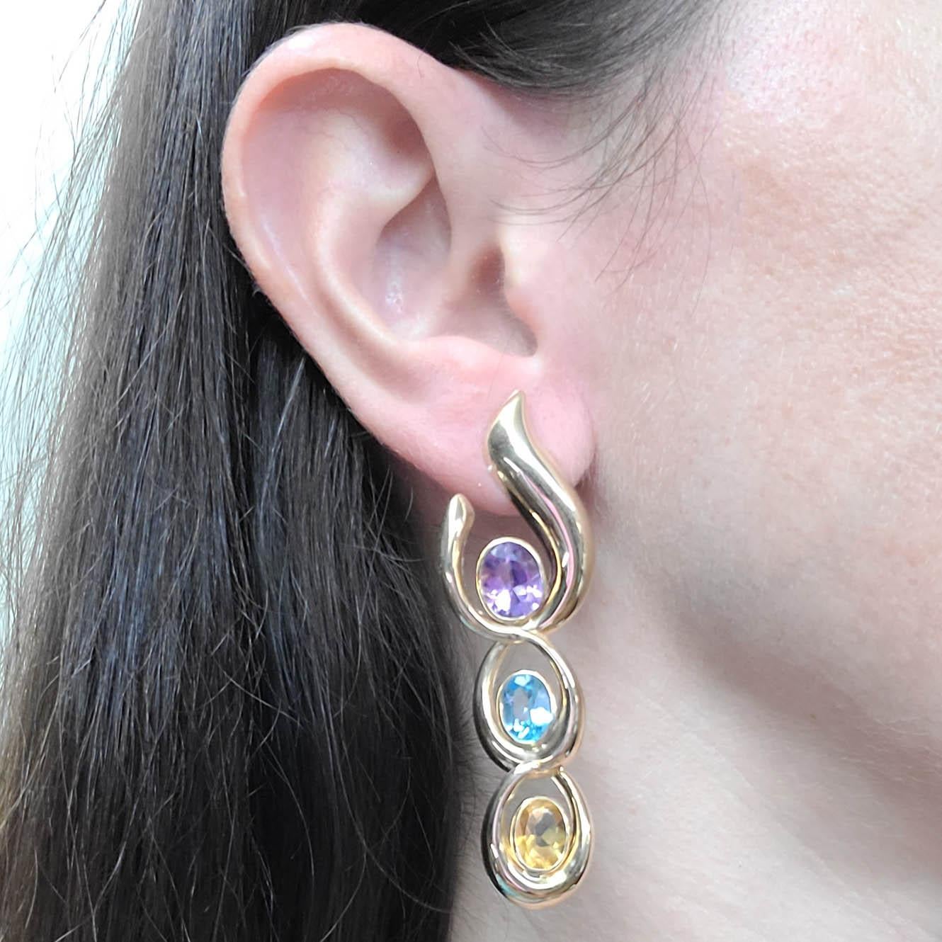 14 Karat Yellow Gold Drop Earrings Featuring Oval Cut Amethyst, Blue Topaz, and Citrine.  The Design Gives The Illusion Of The Earring Wrapping Around Your Ear Lobe.  Articulated Links Allow For Flexible Movement & Swing. Post With Friction Backs.