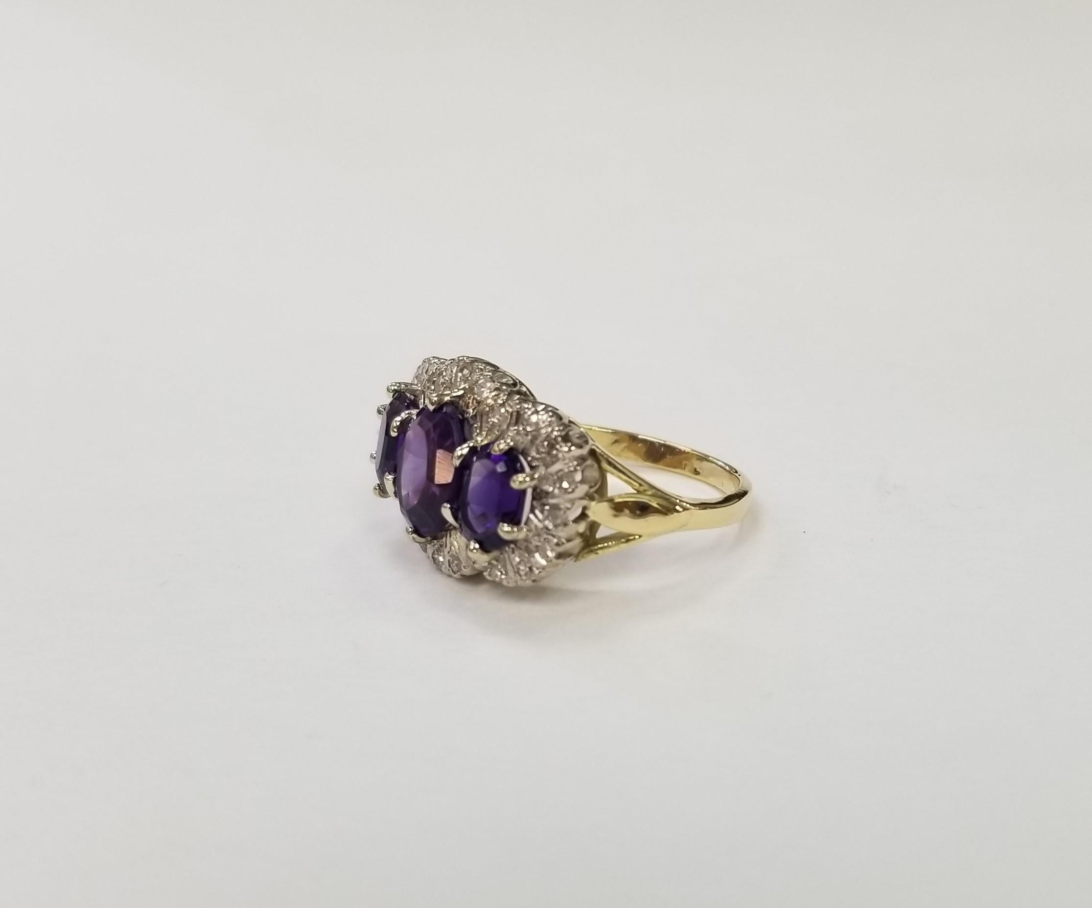 14 Karat Yellow Gold  Amethyst and Diamond Cocktail Ring, 3Amethyst of gem quality weighing 3.50cts. and 24 round single cut diamonds of very fine quality weighing .70pts.  This ring is a size 7.75 but we will size to fit for free.
