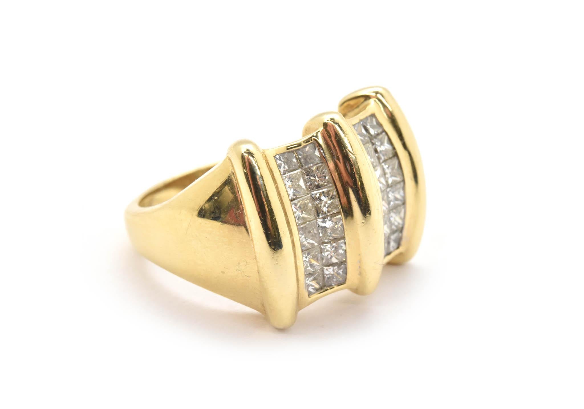 This band is made in 14k yellow gold, and it features invisible-set princess-cut diamonds. The diamonds have a total weight of about 1.50 carats. The stones are graded H-I in color and SI in clarity. The ring measures 15mm wide, and it weighs 10.64