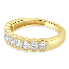 14 Karat Yellow Gold and 9-Stone Half Bezel Set Oval Cut Diamond Band