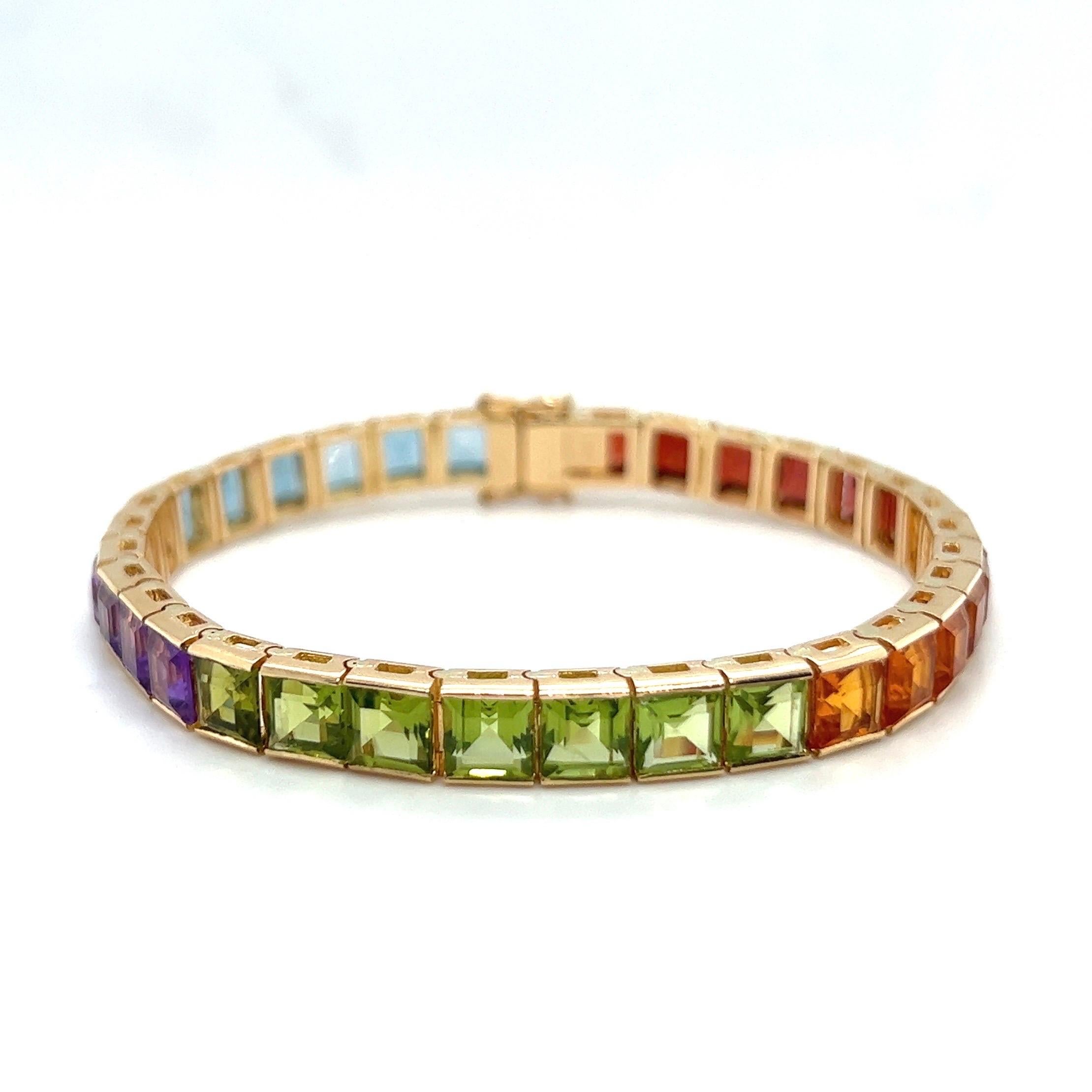 Sporty eye-catching 14 karat yellow gold and colored gemstones rainbow bracelet.

Rivière bracelet crafted in 14 karat yellow gold, designed as a line of 33 coloured gemstone carrés such as aquamarine, amethyst, peridot, citrine, red garnet and