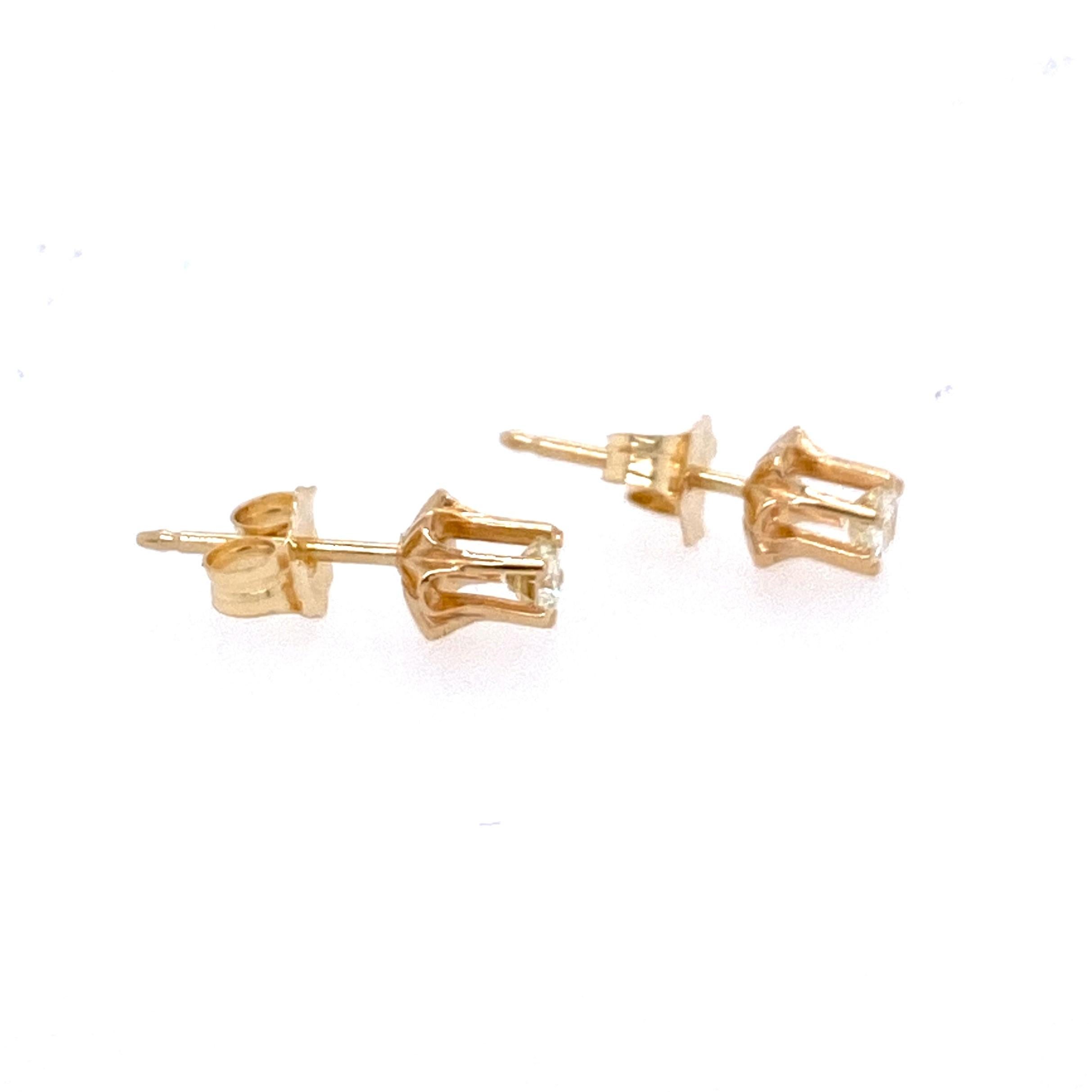 One pair of 14 karat yellow gold (stamped 14) and diamond earrings weighing approximately 0.25 carat total weight with I/J color and SI clarity. Each diamond set in a six prong buttercup setting with friction backs and posts. Circa 1970s.  