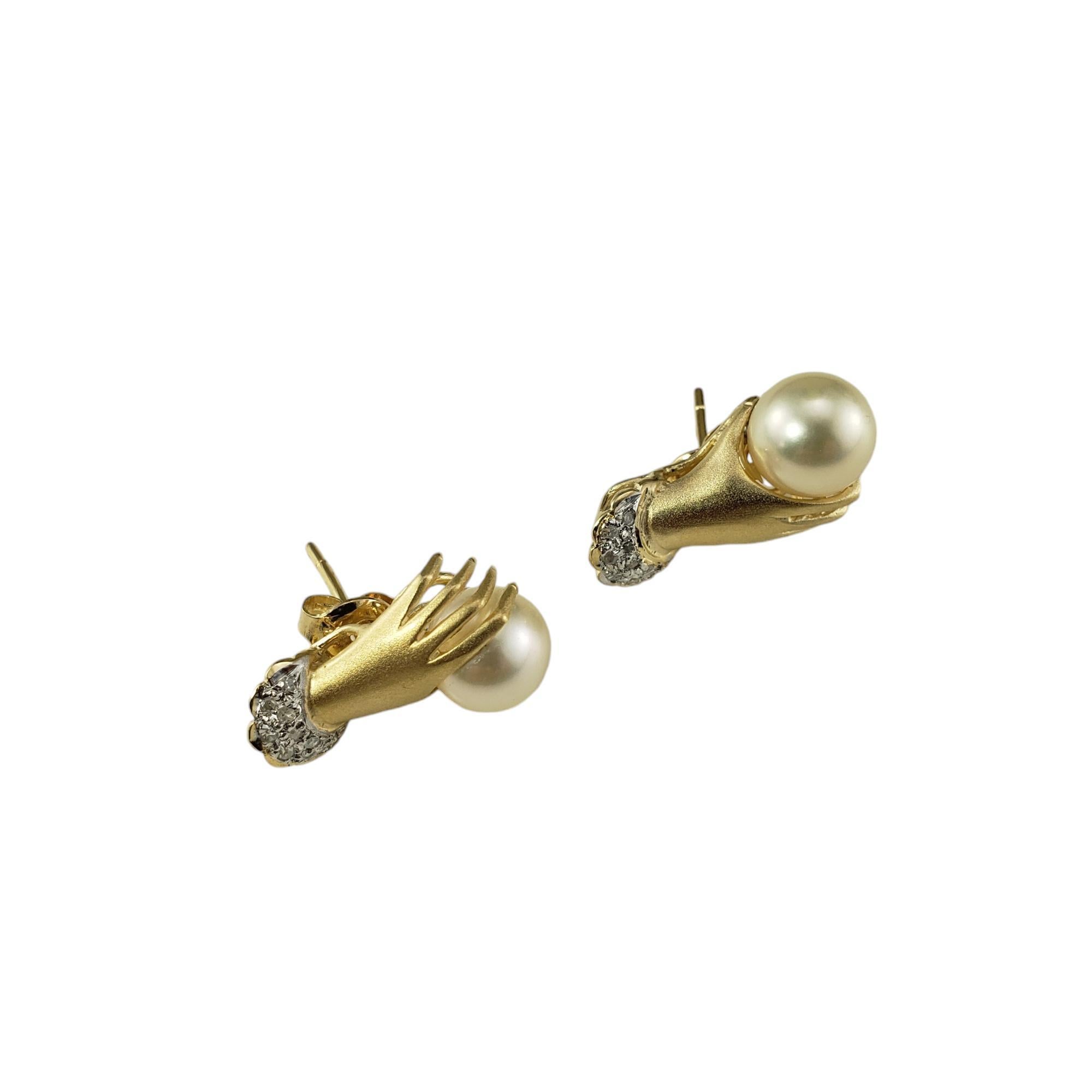 14 Karat Yellow Gold and Diamond Cuffed Hand Holding Pearl Stud Earrings-

These lovely 14K yellow gold earrings each feature a delicate hand holding one cultured pearl (5 mm) decorated with nine round single cut diamonds. Push back