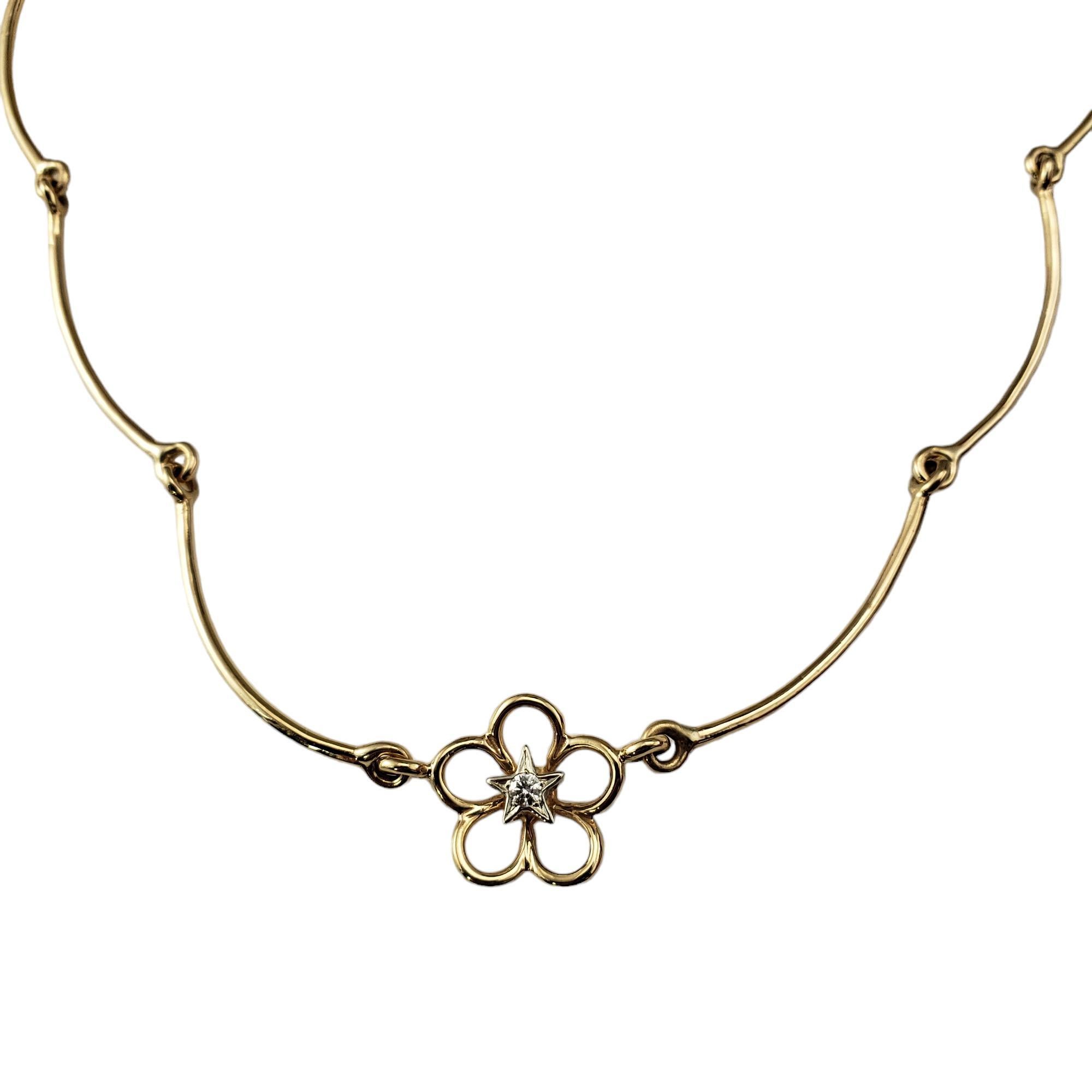 14 Karat Yellow Gold and Diamond Flower Collar /Choker Necklace-

This lovely 14K yellow gold necklace features one round brilliant cut diamond set a floral design.

Approximate total diamond weight: .05 ct.

Diamond color: G

Diamond clarity: