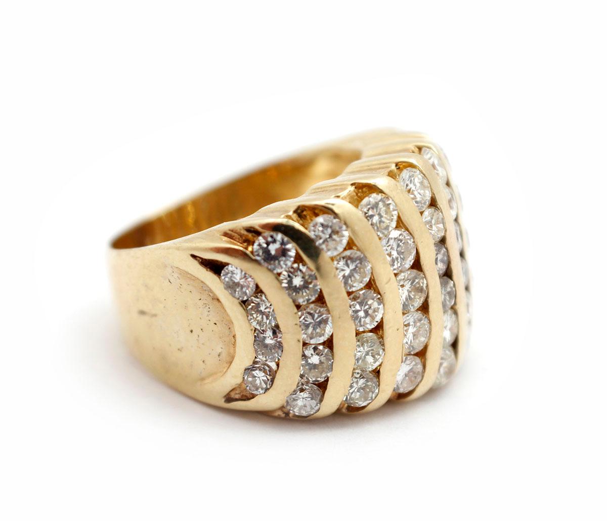 This ring is made in 14k yellow gold, and it holds 10 rows of round brilliant diamonds. There are 50 diamonds in all for an approximate total weight of 2.0 carats. The diamonds are graded H-I-J in color and SI in clarity. The ring measures 14mm