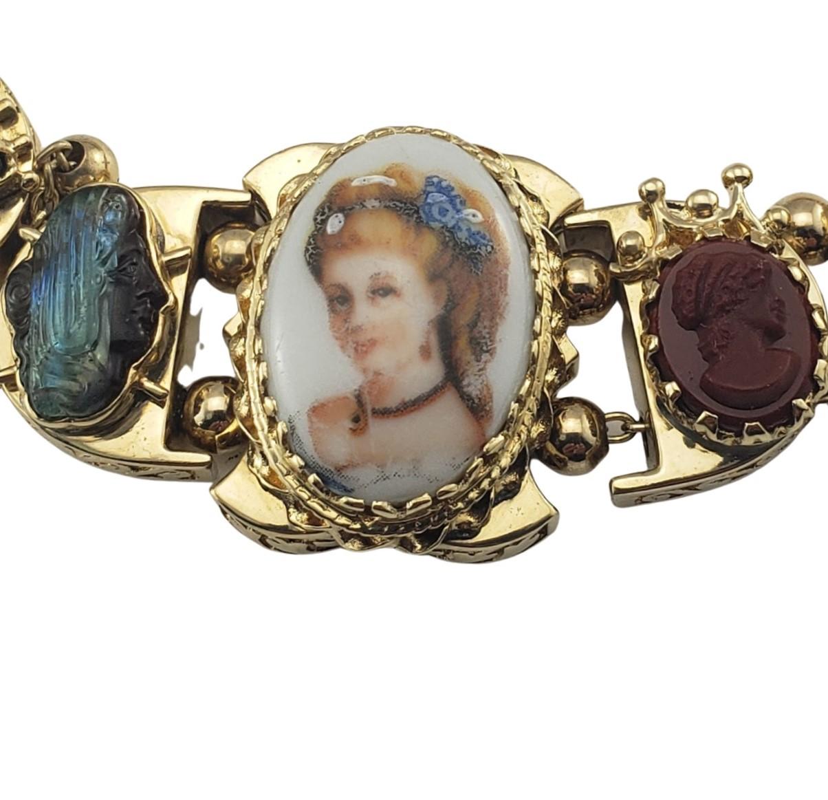 14 Karat Yellow Gold and Gemstone Cameo Bracelet-

This stunning bracelet features a painted cameo along with assorted gemstones set in beautifully detailed 14K yellow gold.  Safety chain closure.  Width:  22 mm.

Size:  6.5 inches

Weight:  28.5