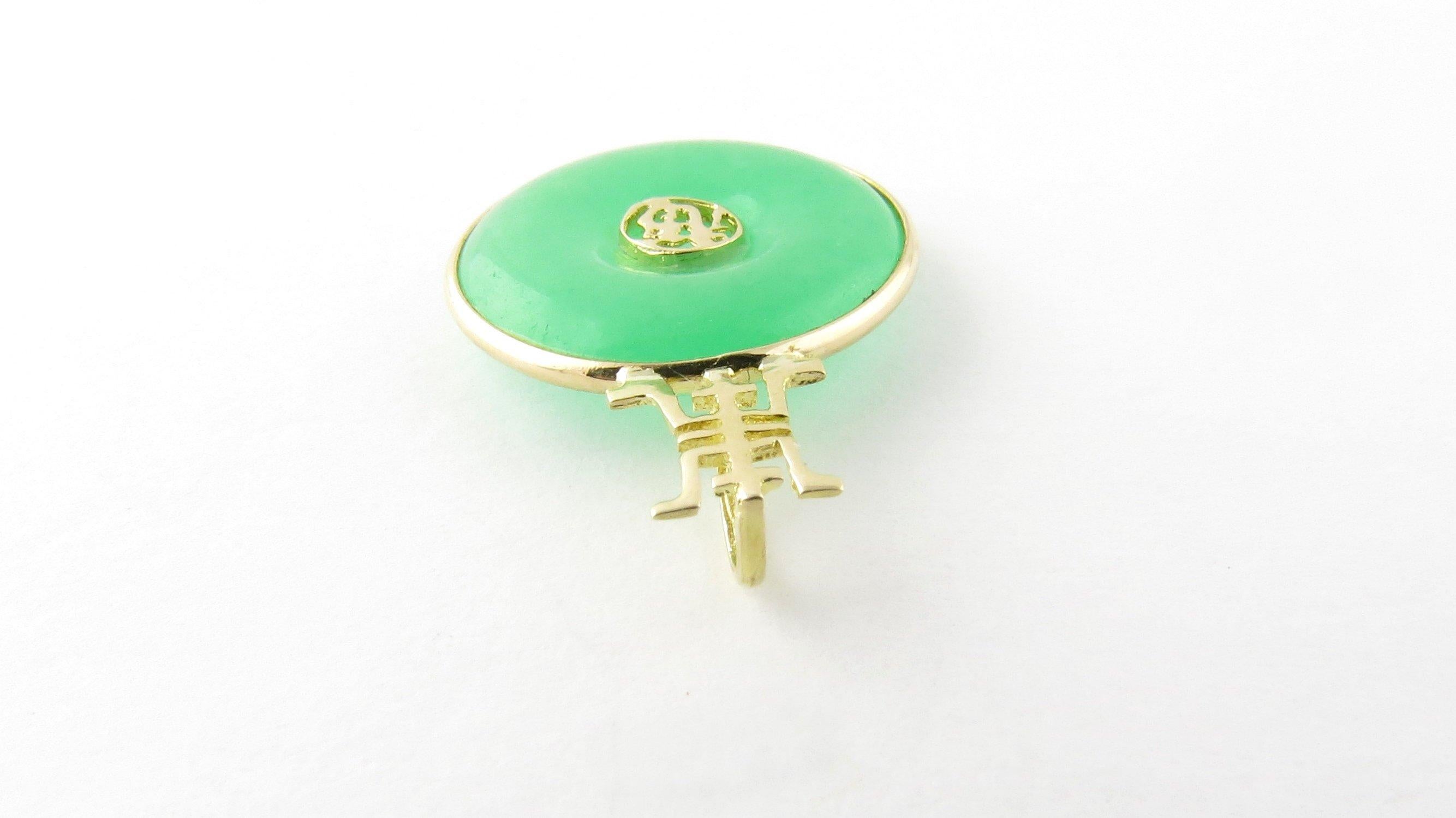 Vintage 14 Karat Yellow Gold and Jade Pendant- 
This lovely jade disc is set in beautifully detailed 14K yellow gold with Chinese characters for good luck in its center. 
Size: 23 mm x 17 mm 
Weight: 1.2 dwt. / 1.9 gr. 
Hallmark: Acid tested for 14K