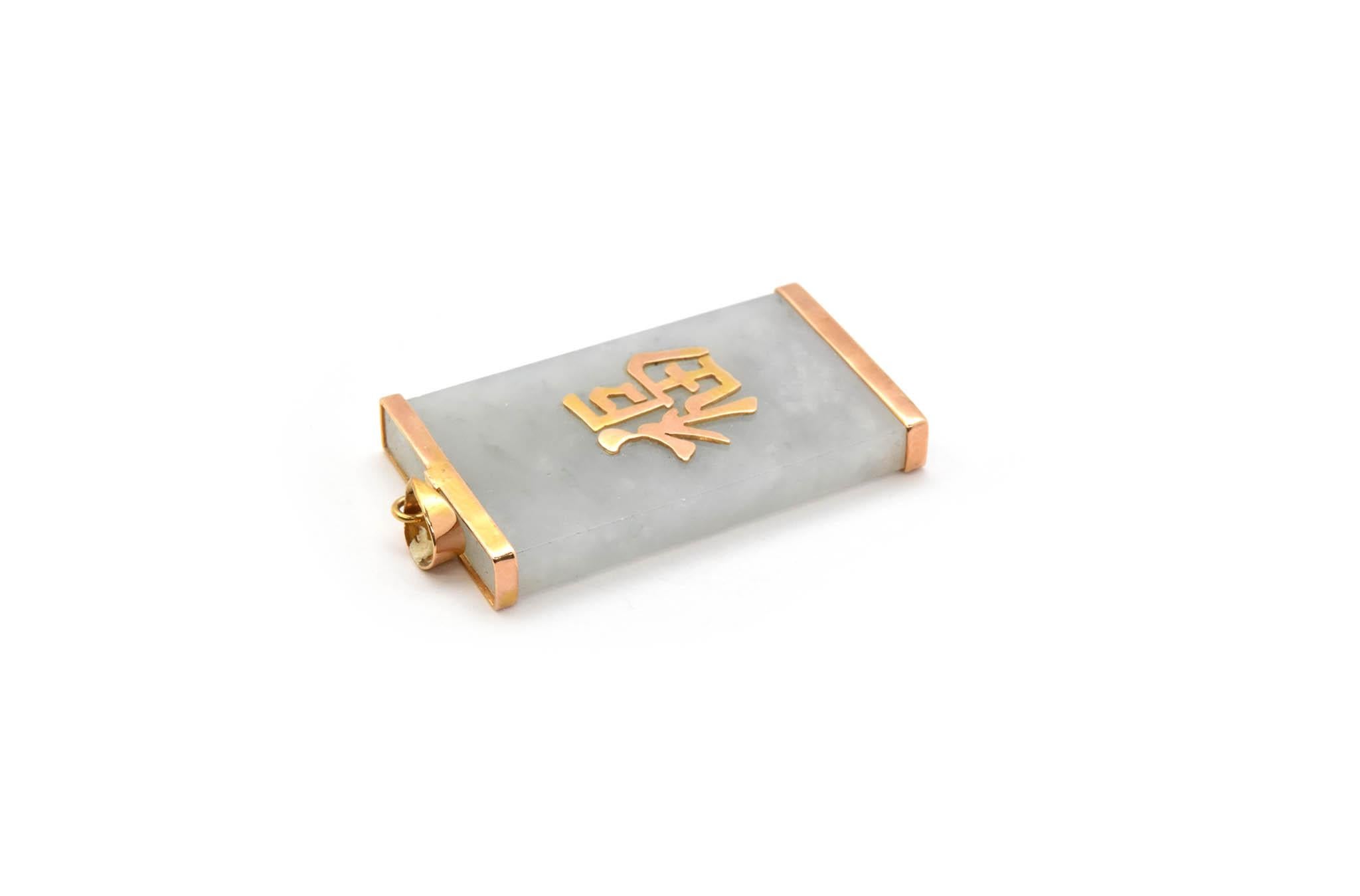 This pendant features a piece of jade accented in 14k yellow gold. The jade features a Chinese character on the front of it. The pendant measures 21x37mm, and it weighs 11.28 grams.

