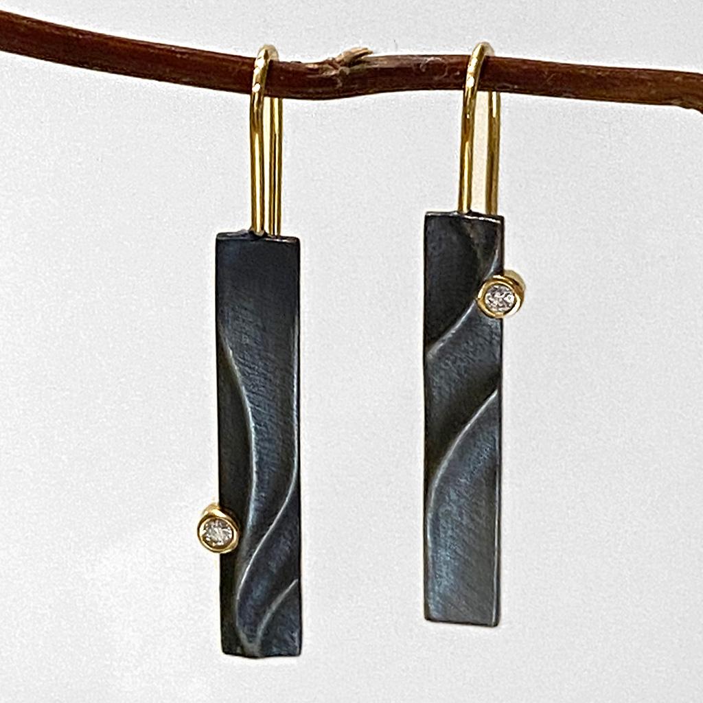 Keiko Mita began her career in Japan, but in 2002 she moved to New York City and founded K.Mita Design. Her modern Black Echo Dangle Earrings are handmade from Oxidized Sterling Silver and feature a 0.02 Carat Diamond set in a 14 Karat Yellow Gold