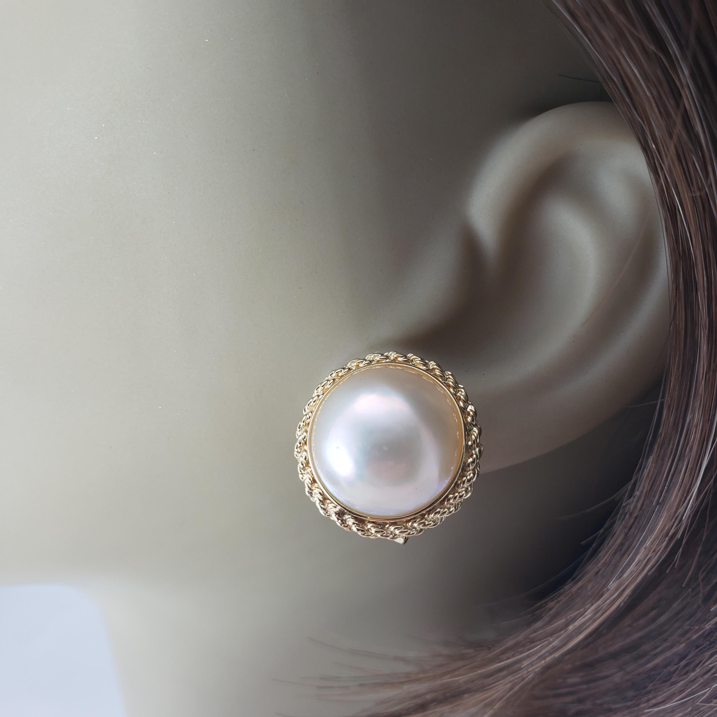 Vintage 14 Karat Yellow Gold and Pearl Earrings-

These lovely earrings each feature one round pearl (14 mm) set in beautifully detailed 14K yellow gold. Omega back closures.

Size: 18 mm

Weight: 5.2 dwt. / 8.1 gr.

Stamped: 20 14K 585

Very good