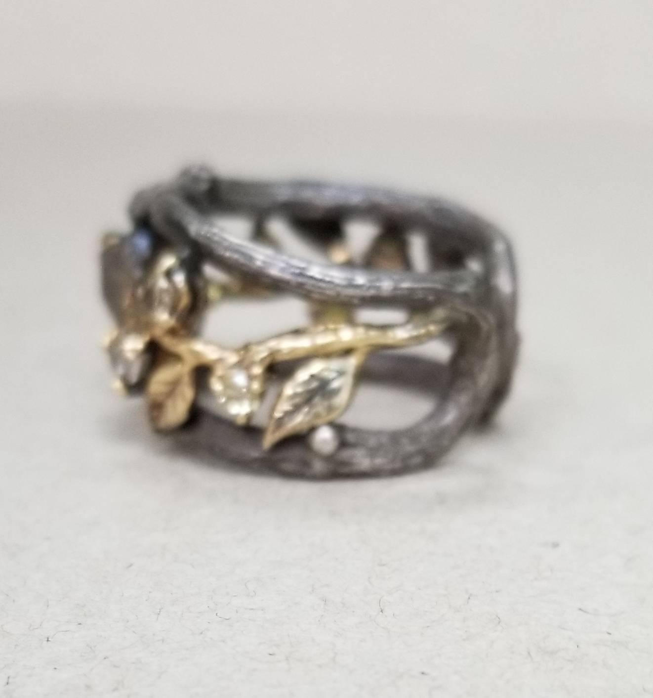 14k yellow gold and silver Gresha signature bark and leaf design with a rough uncut natural black-grey diamond weighing .51pts. and 6 round brown diamonds weighing .30pts.  The ring is antiqued and is a size 6 with an adjustable bottom. 
*this