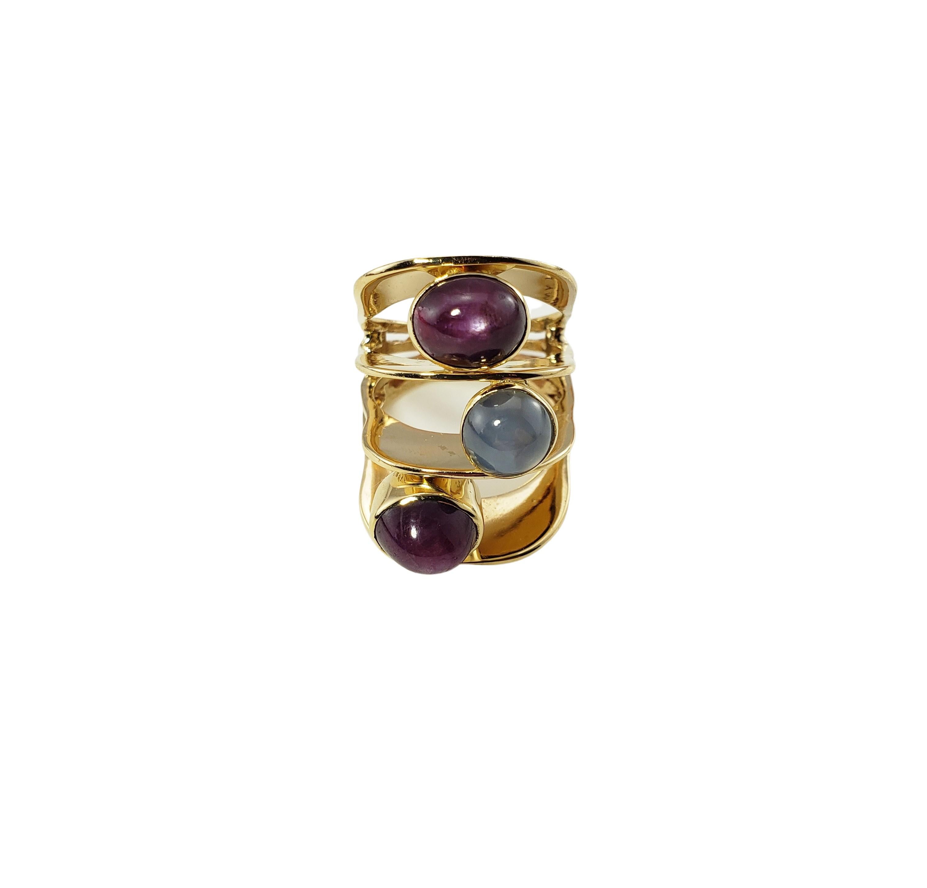 14 Karat Yellow Gold and Star Sapphire Ring Size 10.25 GAI Certified-

This stunning ring features three oval cabochon star sapphires (one blue, two purple 10 mm x 8 mm each) set in beautifully detailed 14K yellow gold.  Width:  29 mm.  Shank:  7