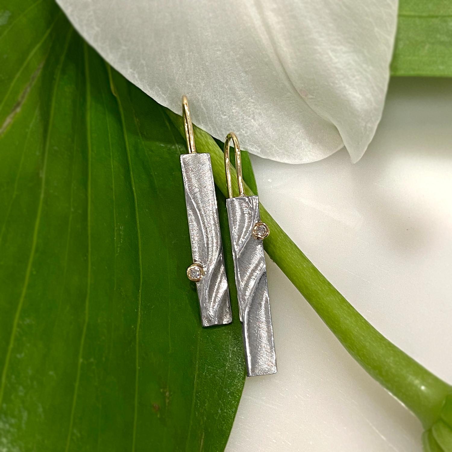 Keiko Mita's  modern Echo Dangle Earrings are handmade from Sterling Silver and accented with 0.04 Carat Diamonds (total weight) set in 14 Karat Yellow Gold bezels. The contemporary earrings have 14 Karat Yellow Gold ear wires and are 38 mm long and
